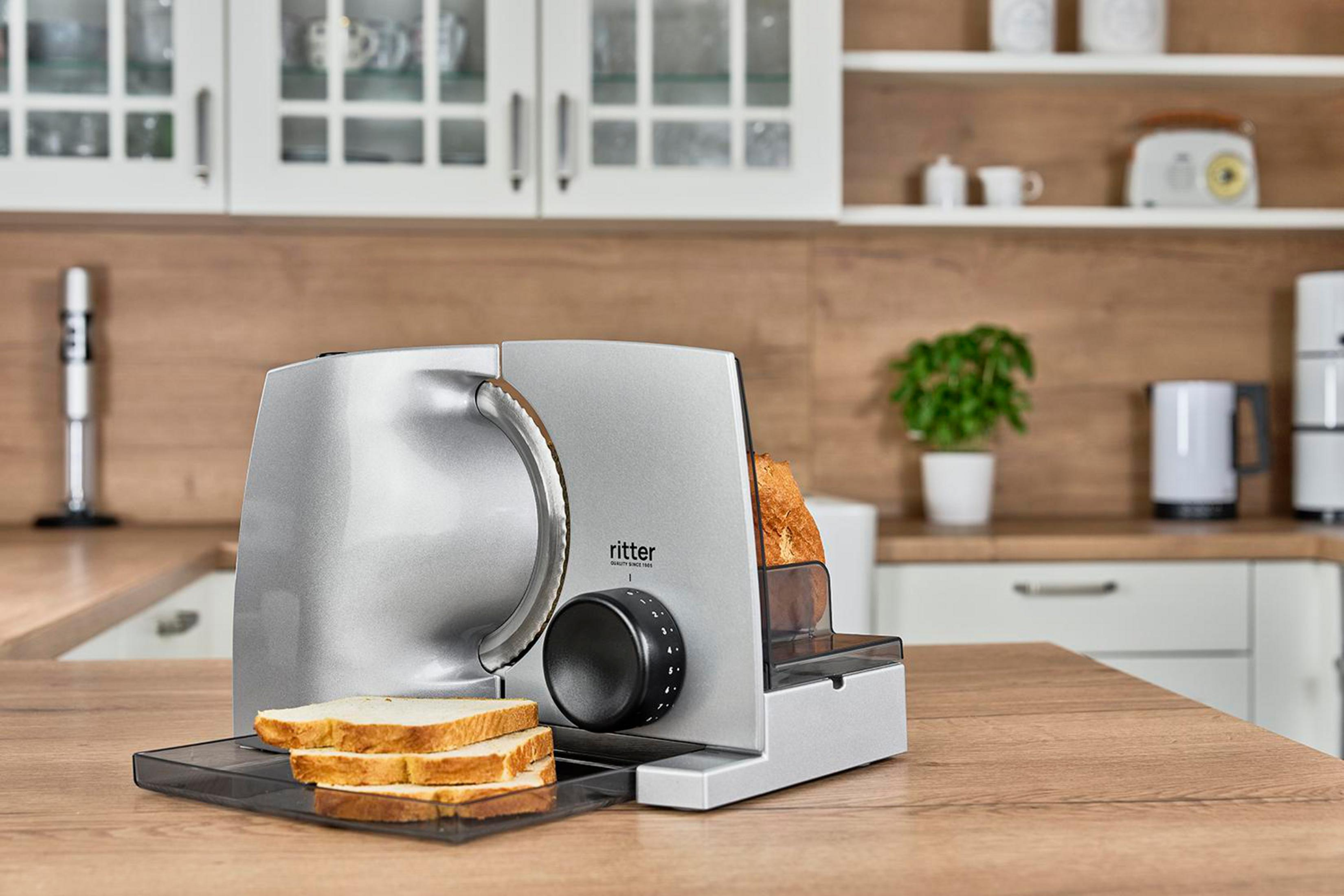 Srebrna krajalnica do chleba z trzema kromkami białego chleba.