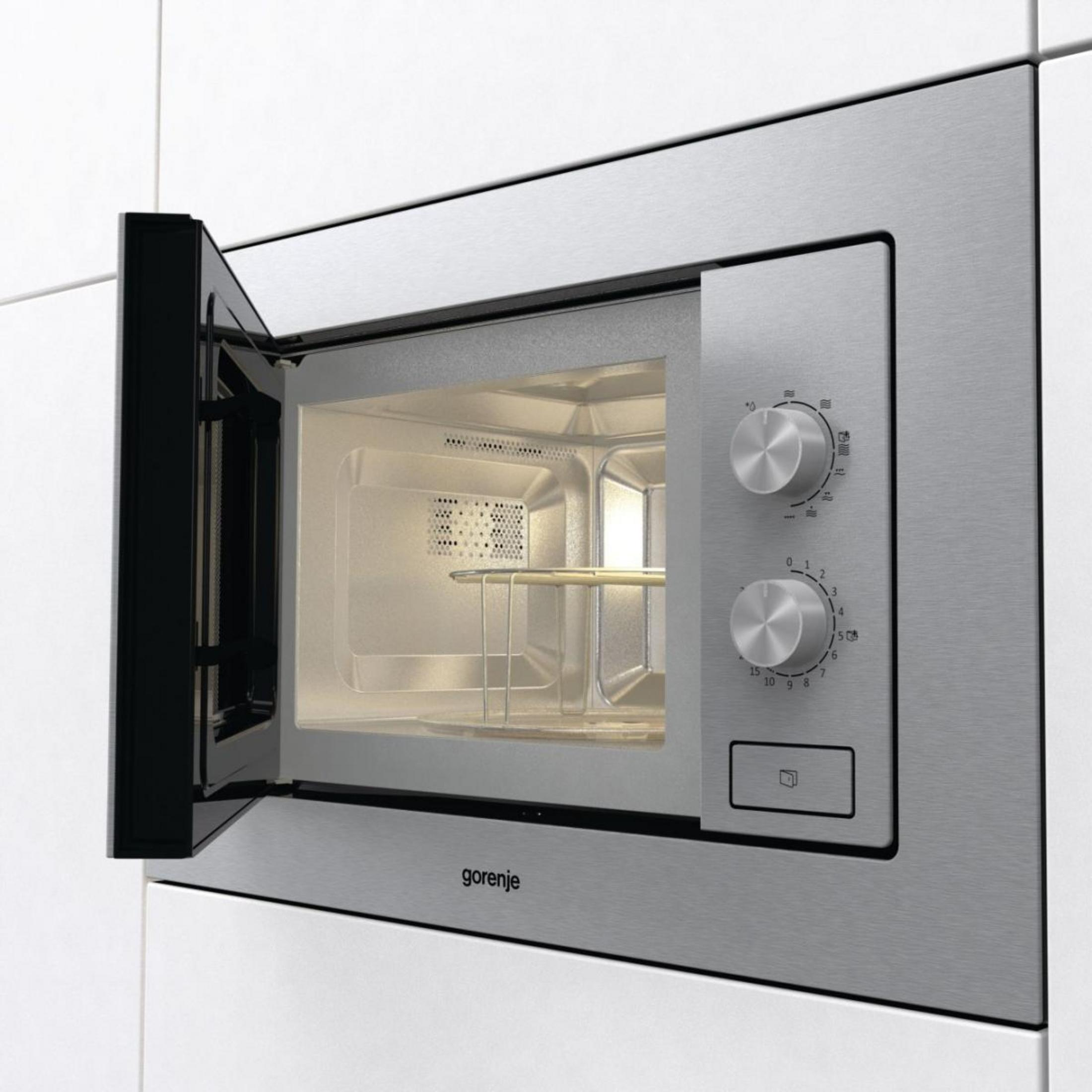 Un forno a microonde Gorenje con porta aperta, color argento, con due manopole e un pulsante.