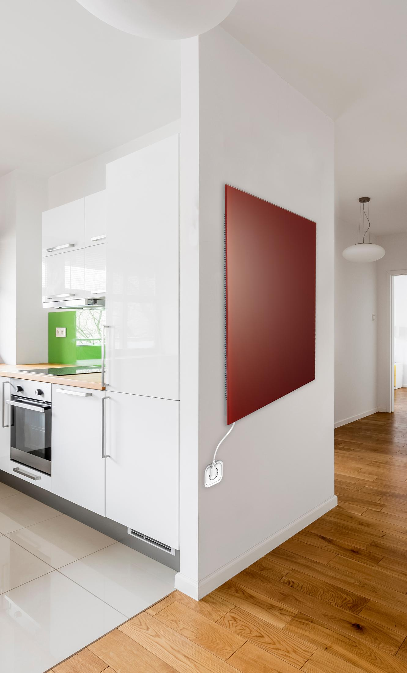 Ein rotes Heizpaneel an einer weißen Wand neben einer modernen Küche.