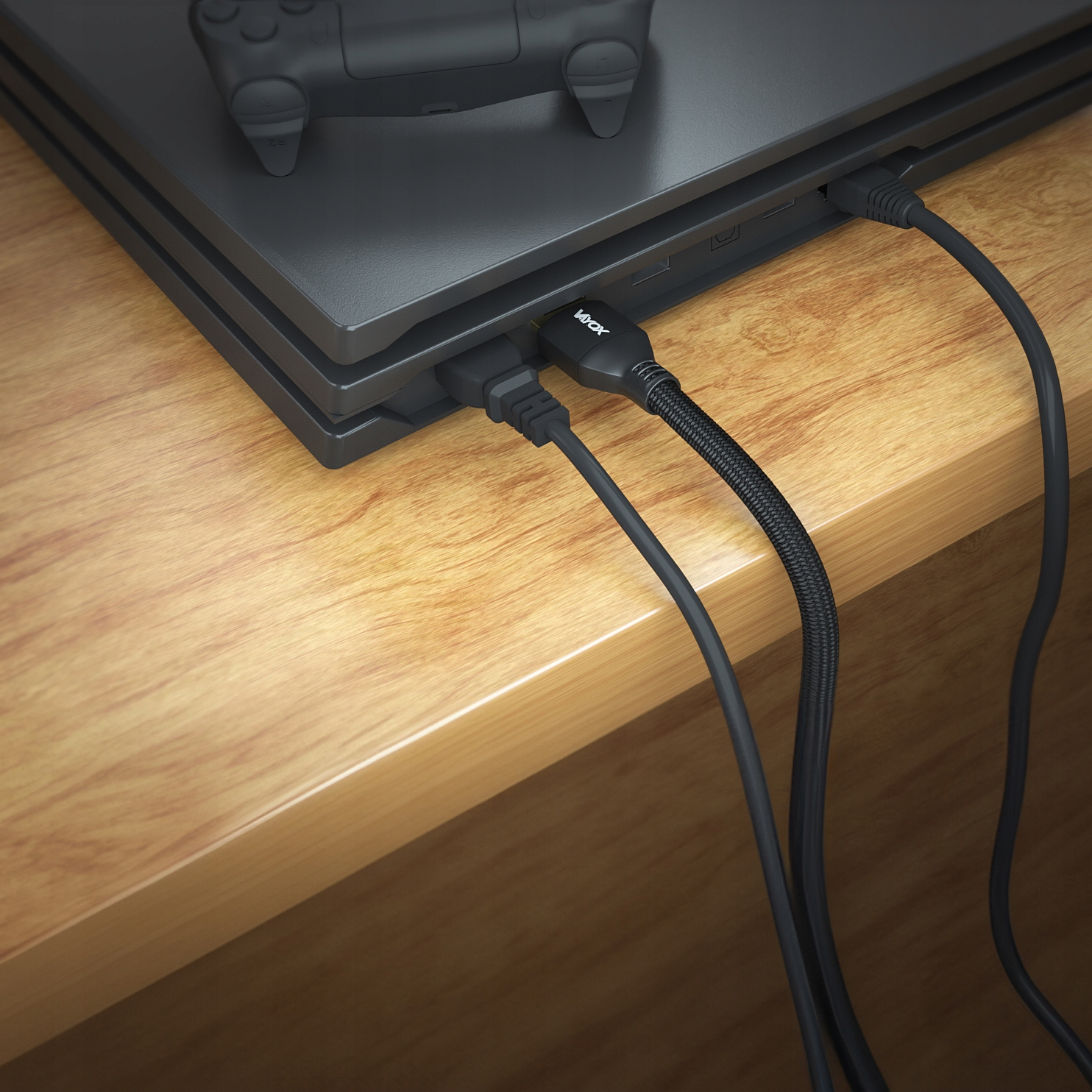 Czarna konsola do gier z podłączonymi kablami na drewnianym stole.