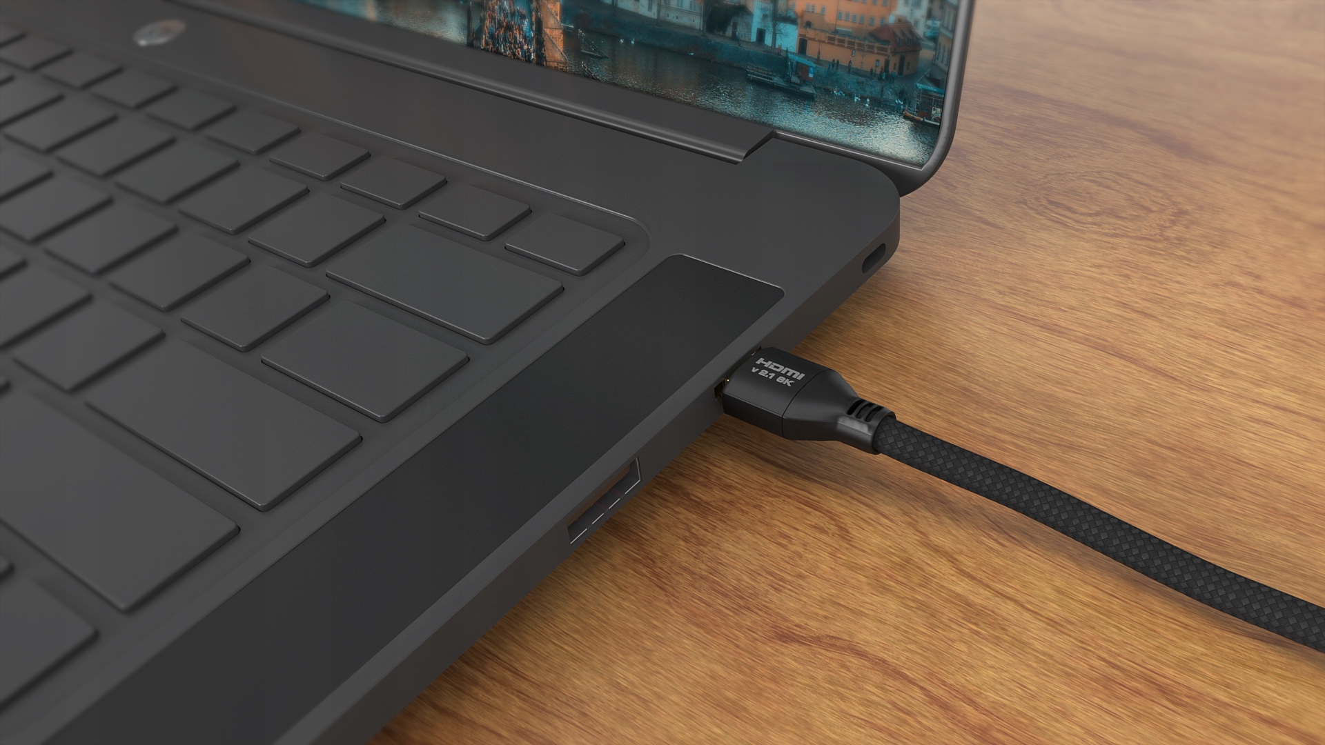 Czarny kabel HDMI podłączony do laptopa na drewnianym biurku.