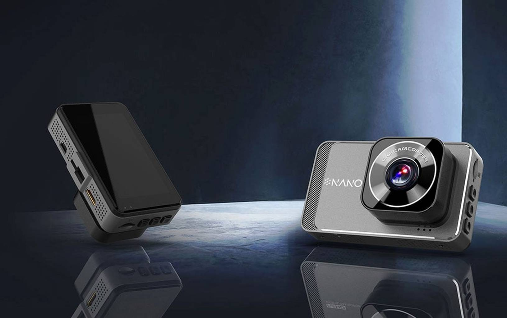 Twee zwart-grijze elektronische apparaten, een dashcam en een klein scherm, op een reflecterend oppervlak.