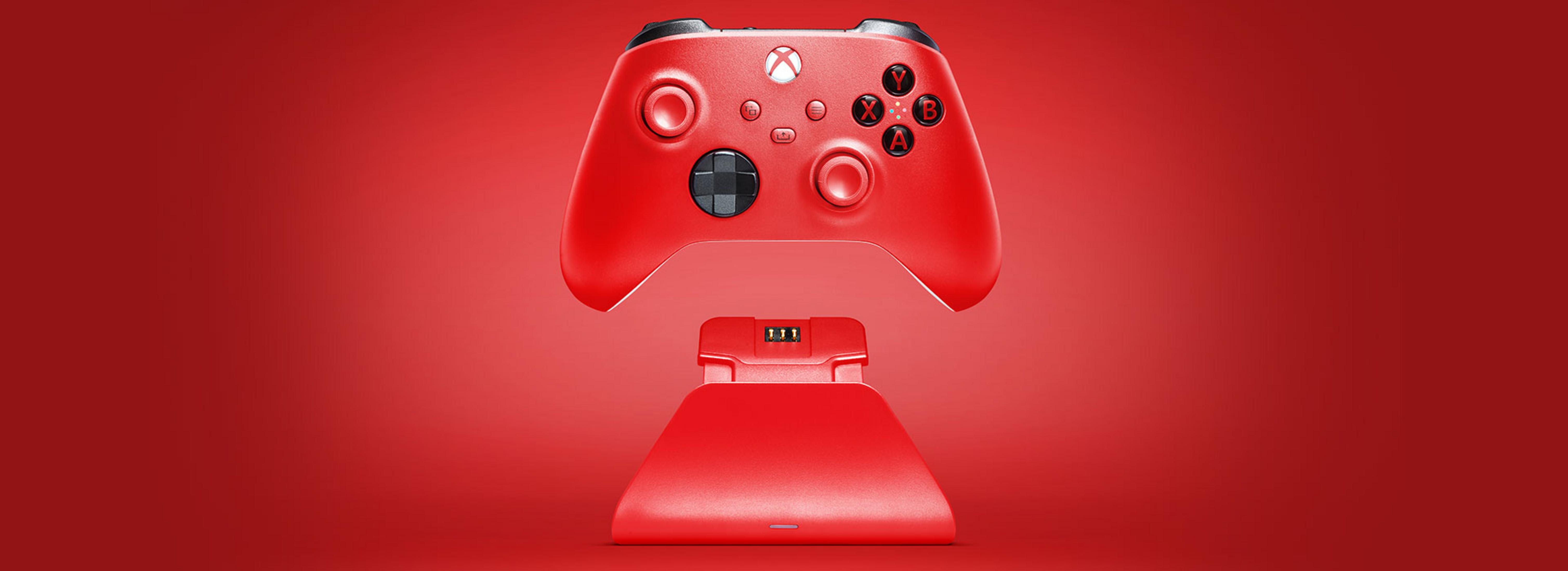 Ein roter Xbox-Controller ruht auf einer roten Ladestation vor rotem Hintergrund.