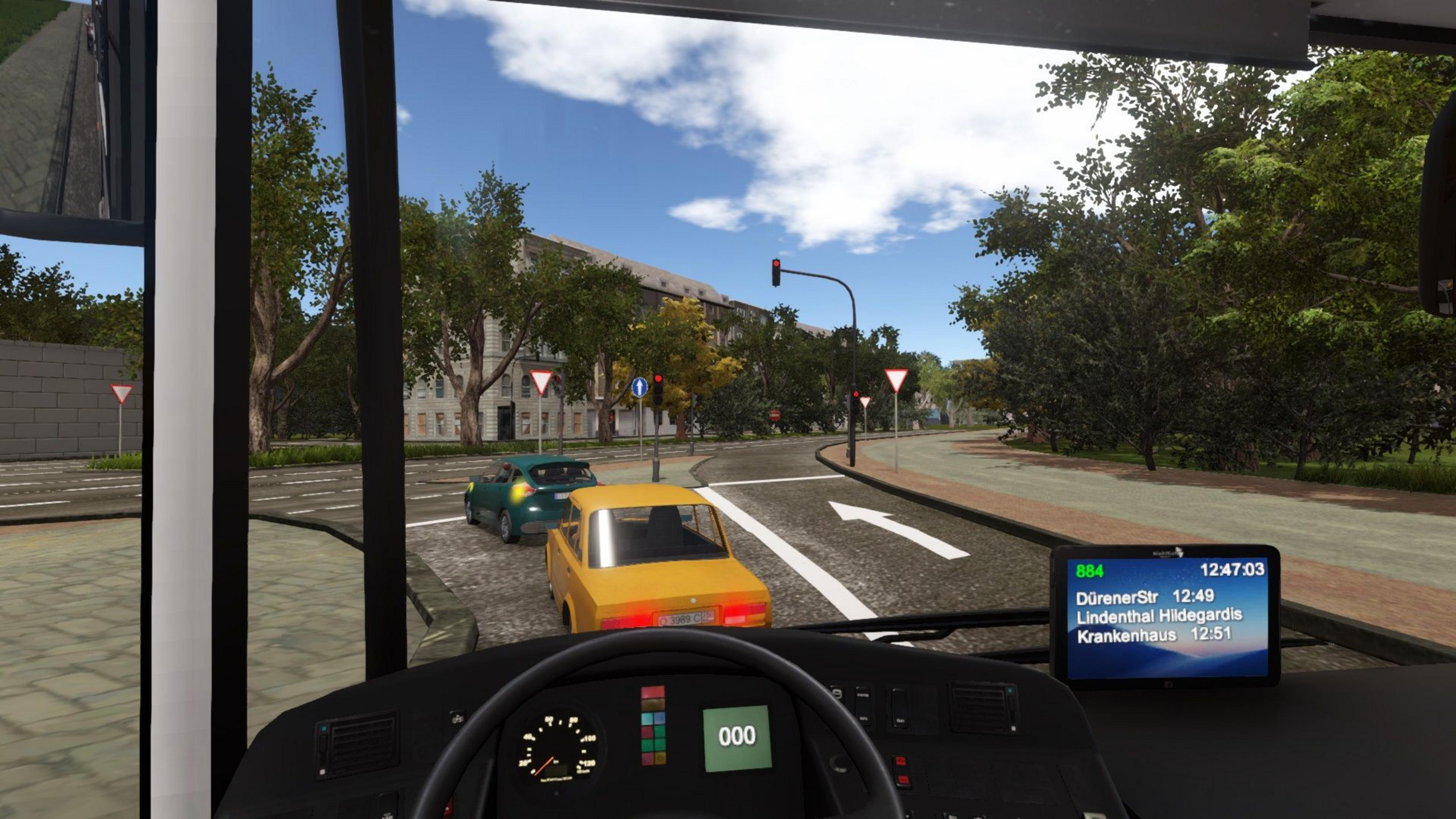 Blick aus einem Bus auf eine Straße mit gelbem Auto und Ampel.