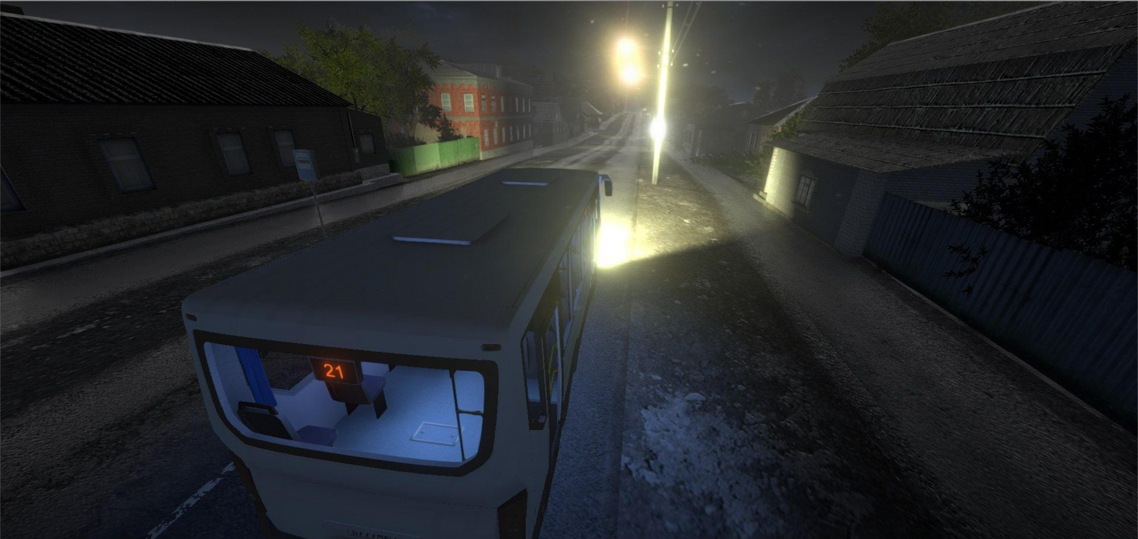 Ein Bus fährt nachts durch eine dunkle Stadtstraße mit Laternenlicht.