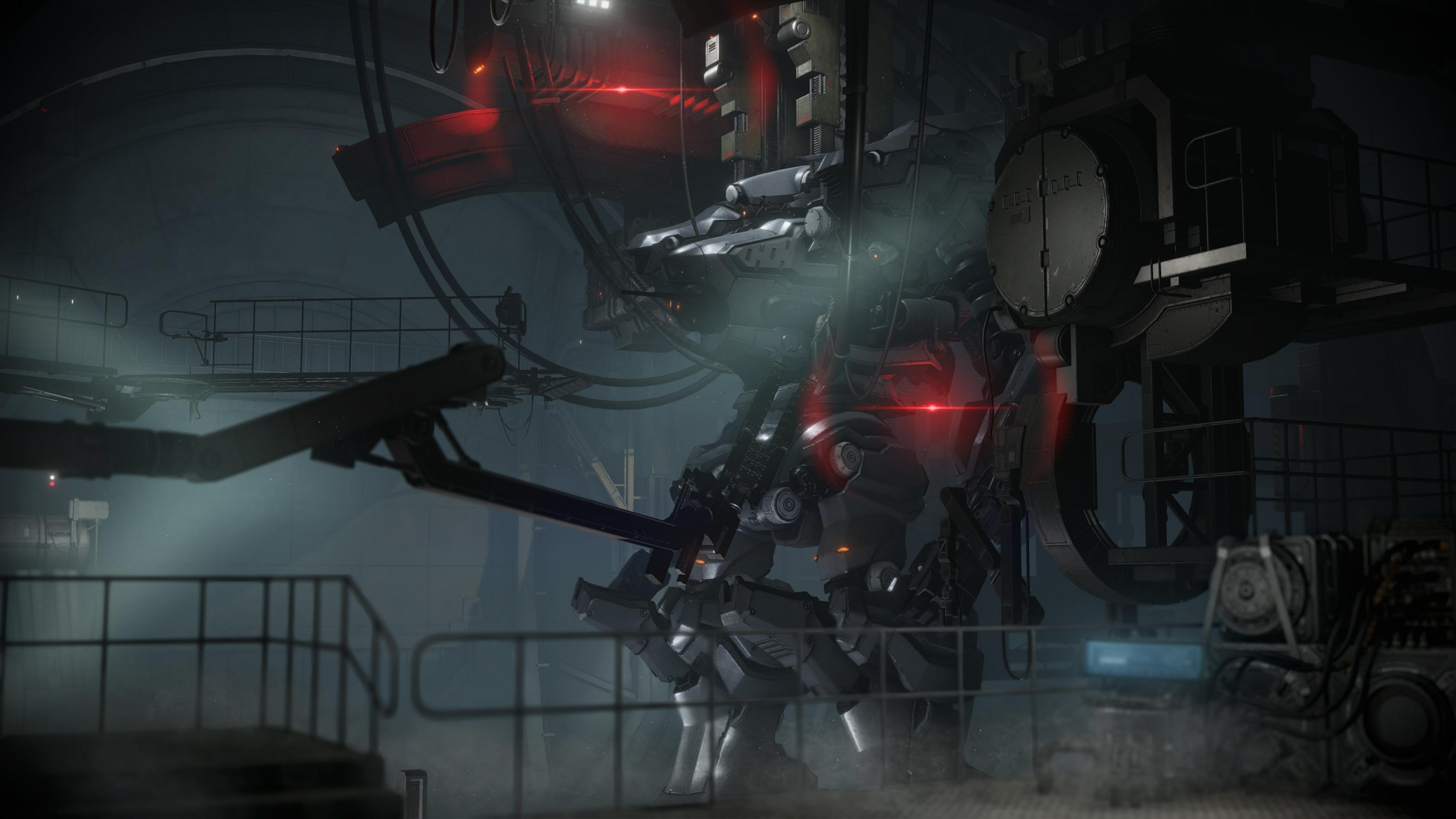 Ein großer grauer Mech mit roten Lichtern steht in einer dunklen, industriellen Halle.
