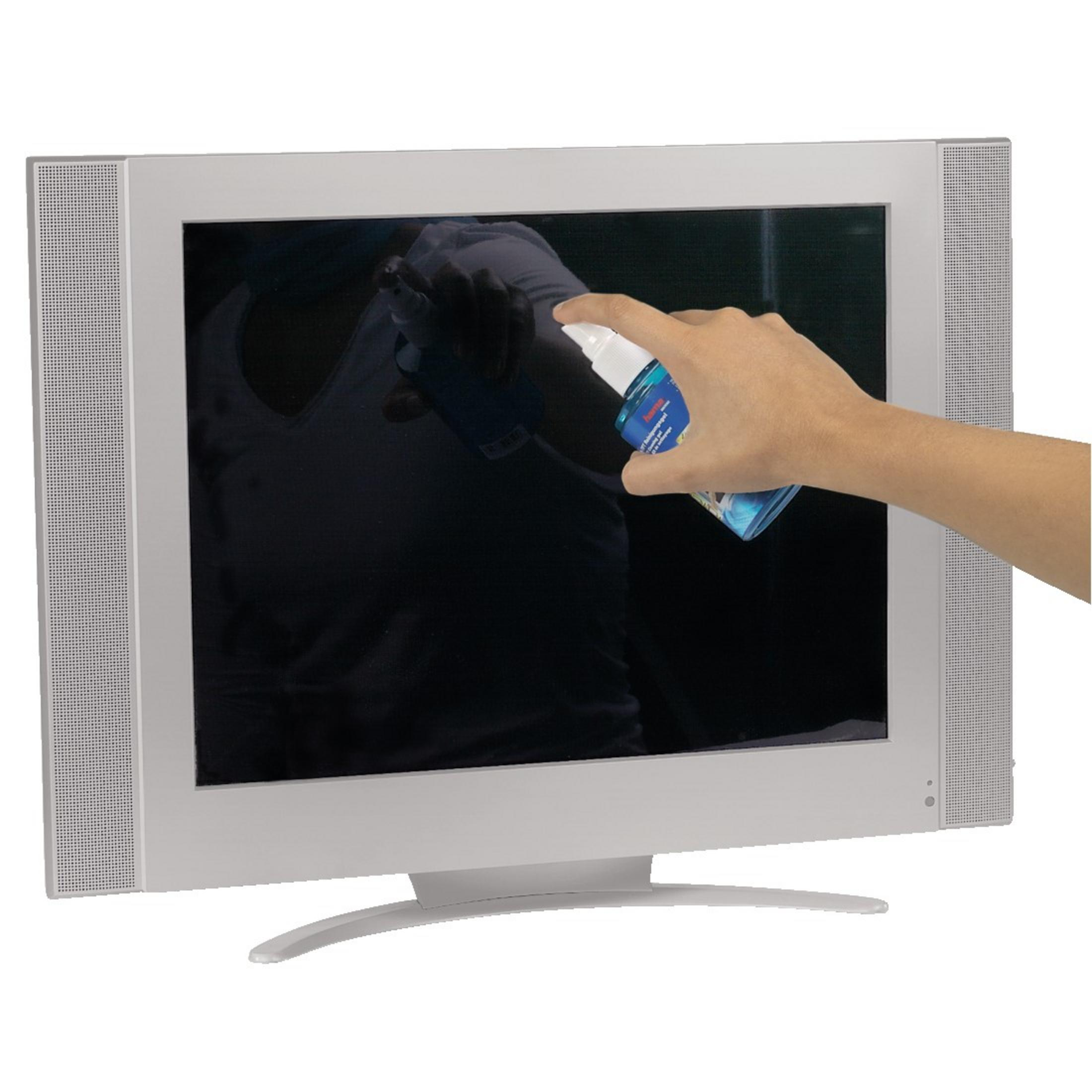 Ręka rozpyla środek czyszczący na srebrny ekran monitora.