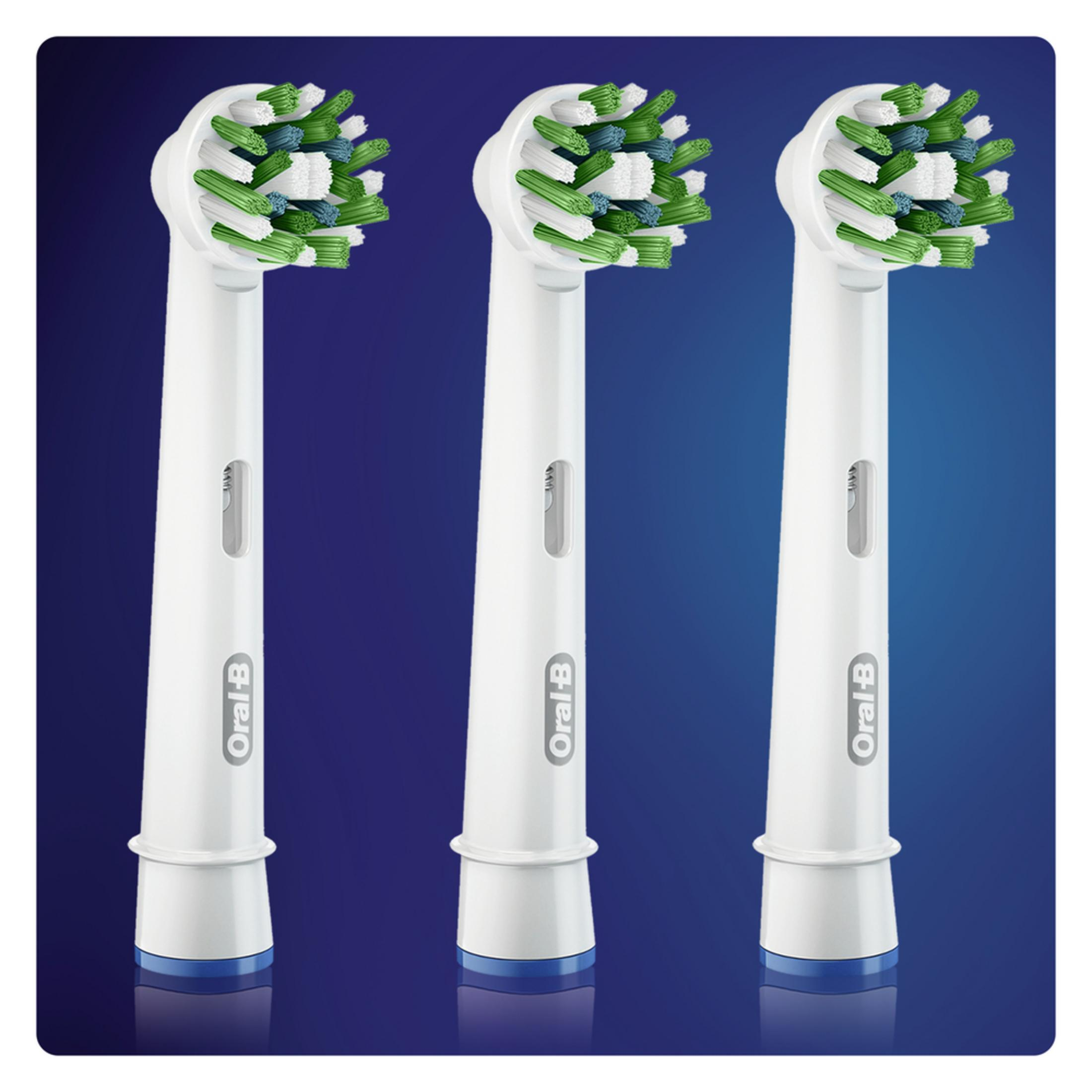 Tre testine Oral-B bianche con setole verdi e blu su sfondo blu.
