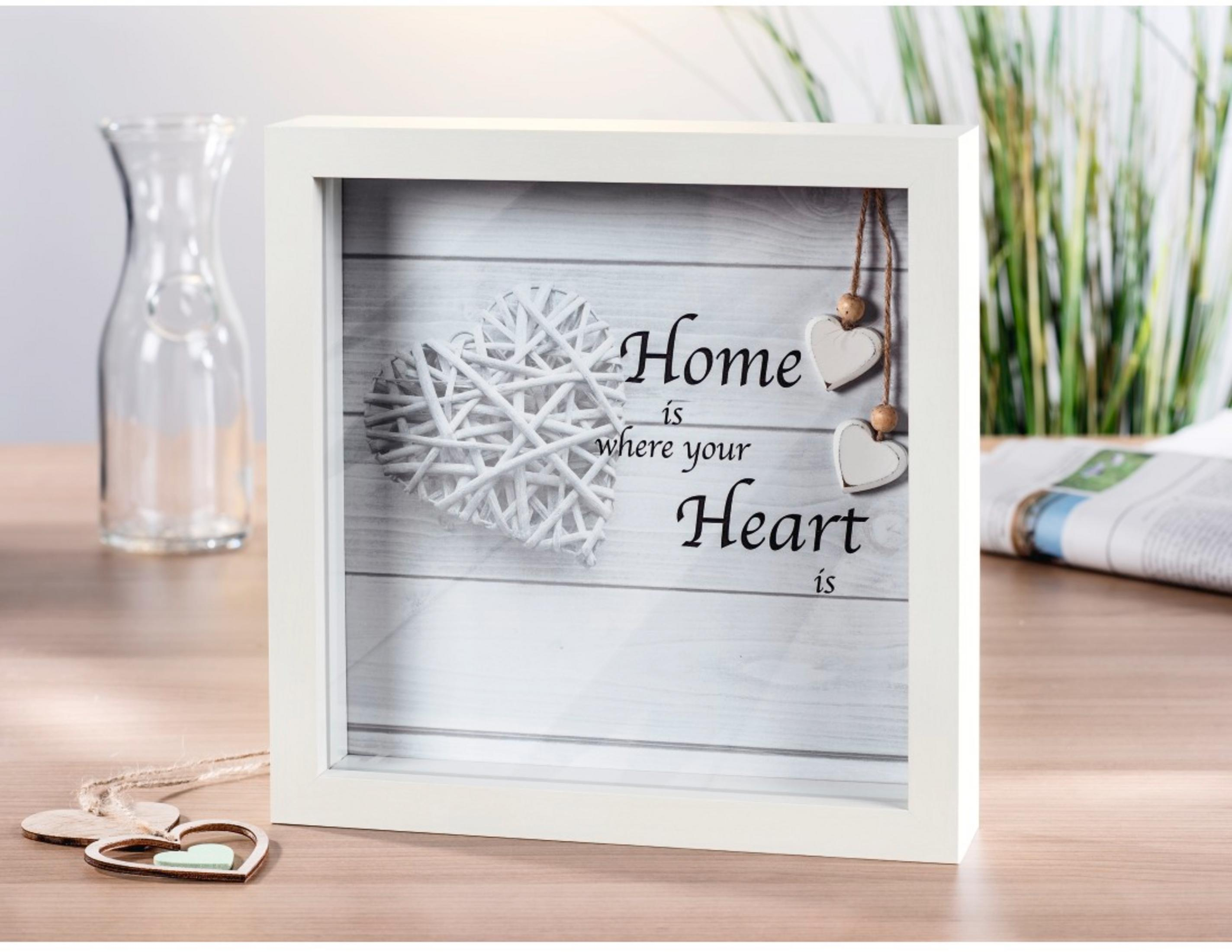 Ein weißer Bilderrahmen mit Herzen und dem Text 'Home is where your Heart is'.