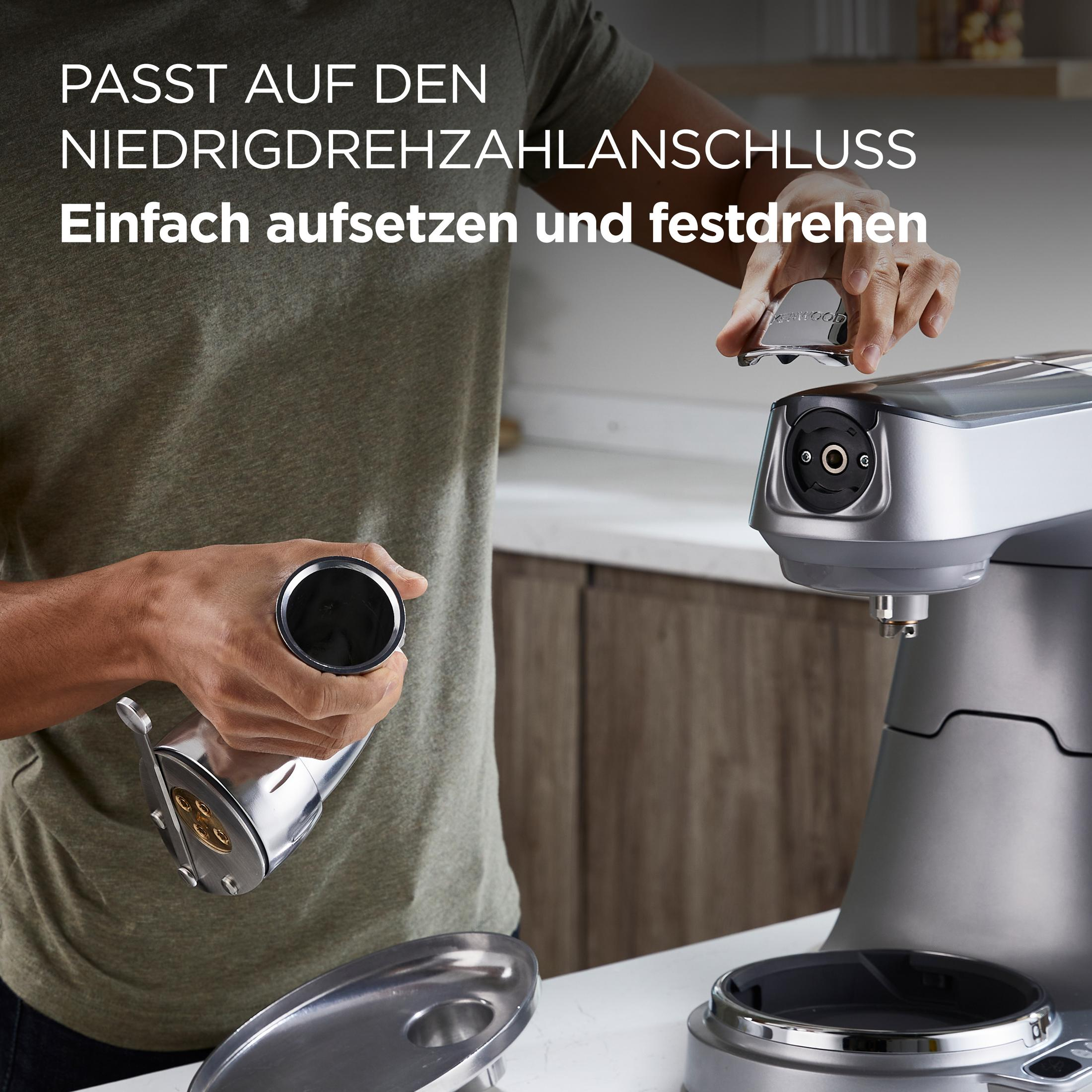 Osoba montuje przystawkę do srebrnej maszyny. Proste mocowanie.