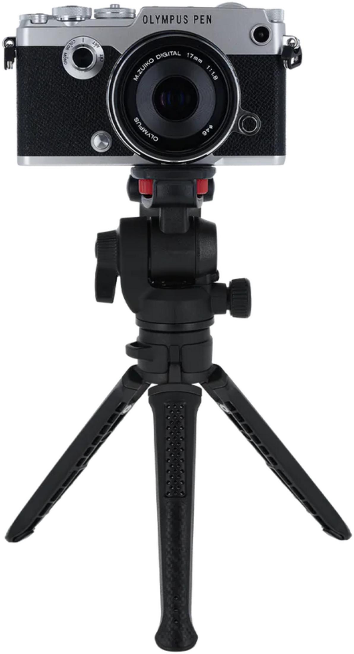 Fotocamera OLYMPUS PEN argento su un mini treppiede nero a tre gambe.