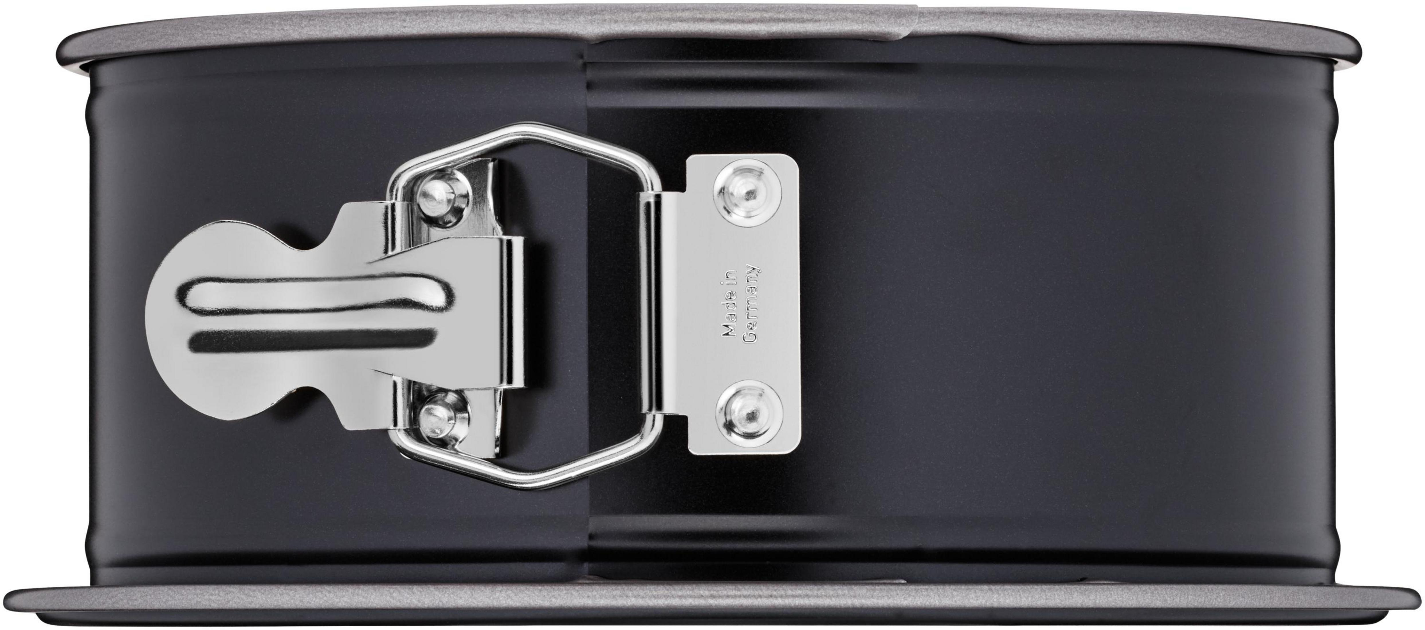 Ciemna, okrągła forma do ciasta z srebrnym zapięciem na klamrę i 