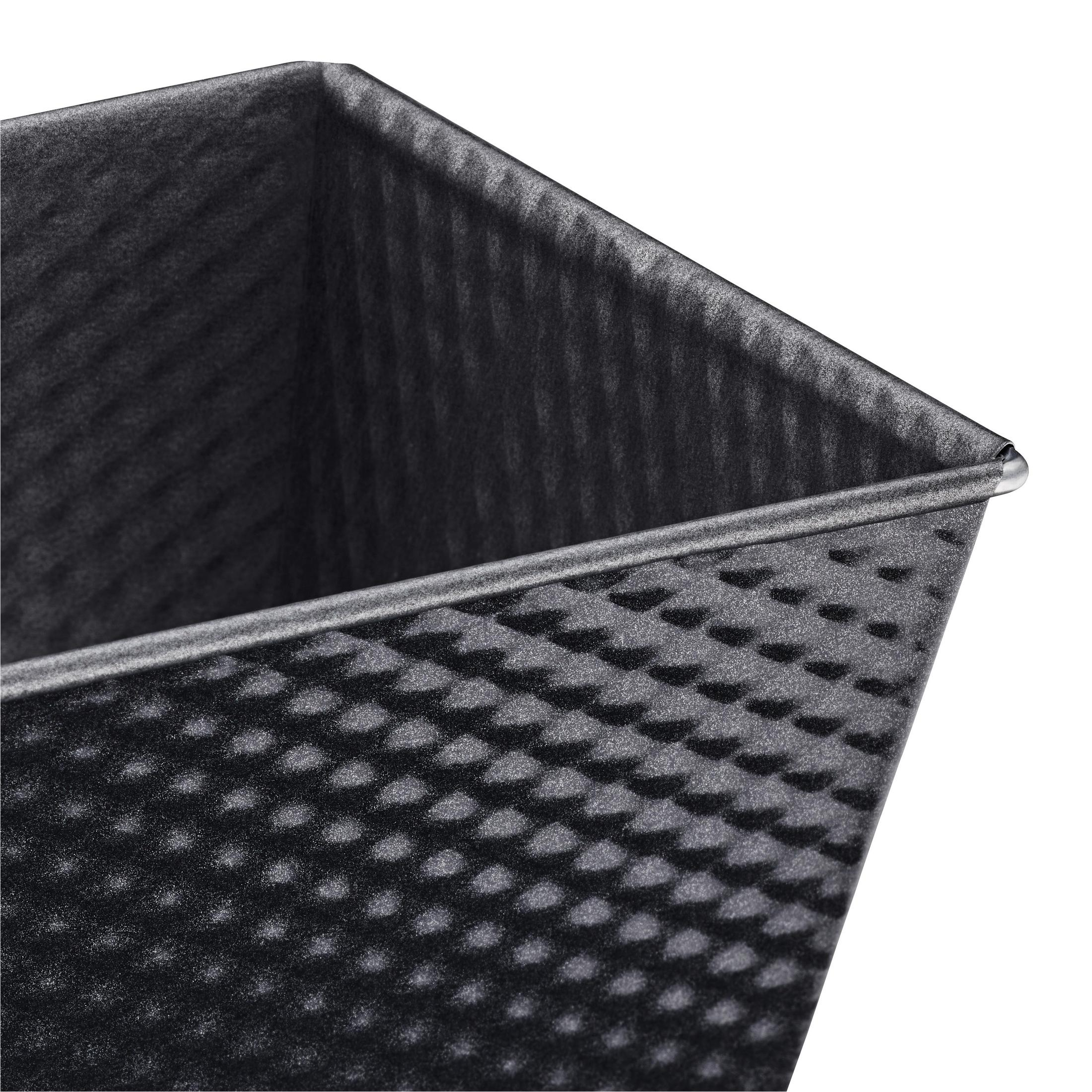 Zbliżenie szarej, prostokątnej formy do pieczenia chleba z wzorem plastra miodu.