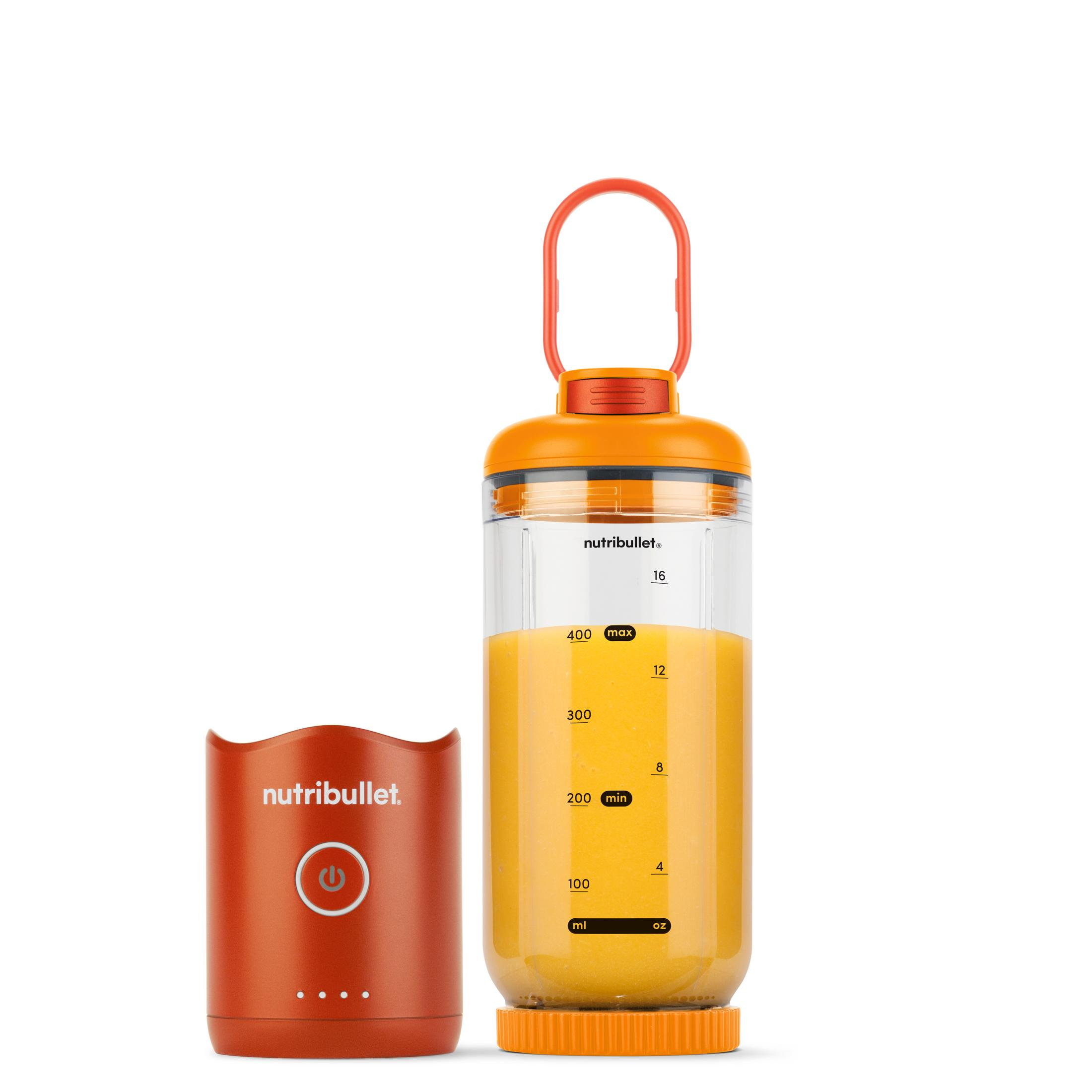 Ein orangefarbener Mixer mit einem Becher gefüllt mit orangem Saft und einem separaten Sockel.