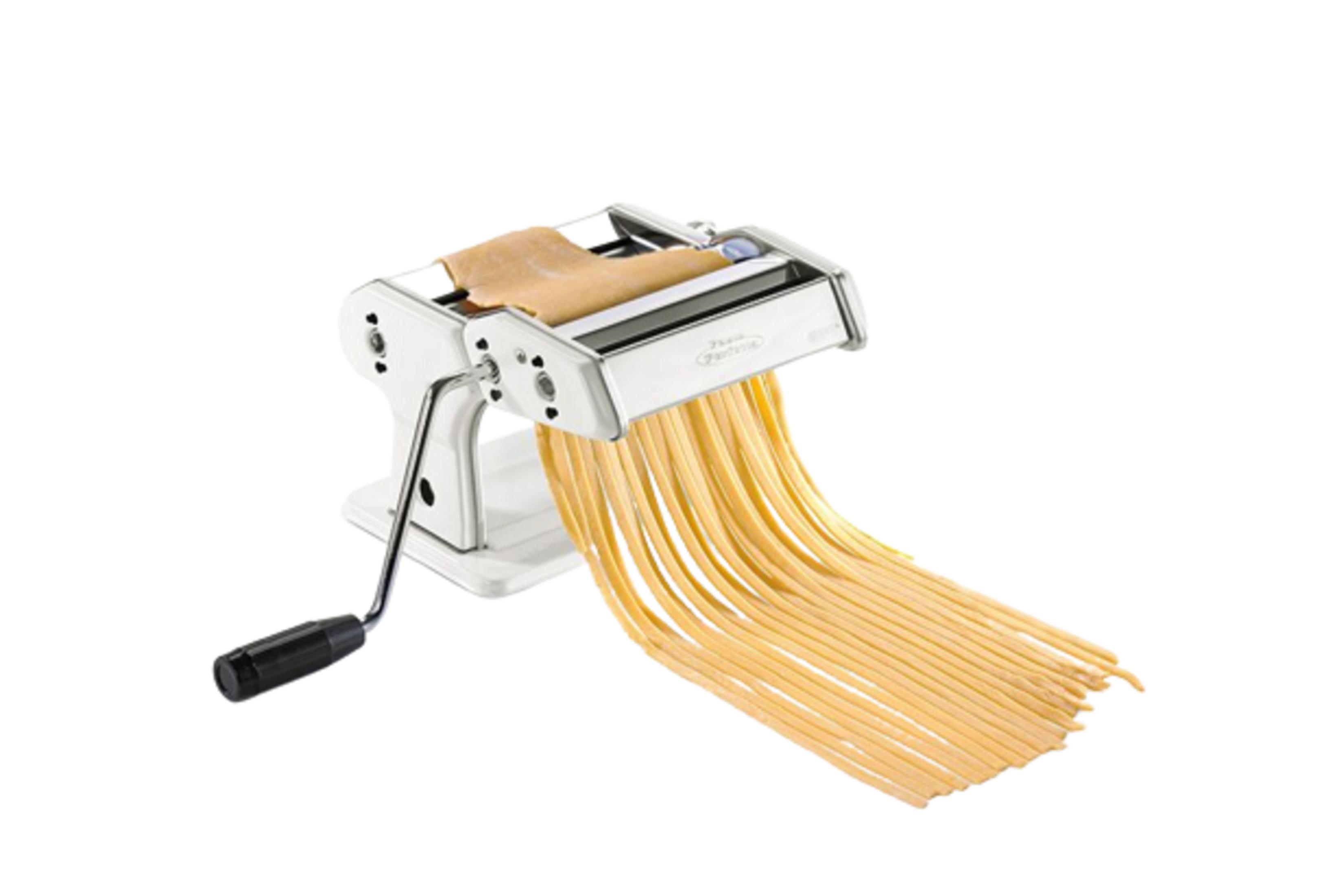 Una macchina per la pasta bianca con una sfoglia di pasta e tagliatelle fresche.