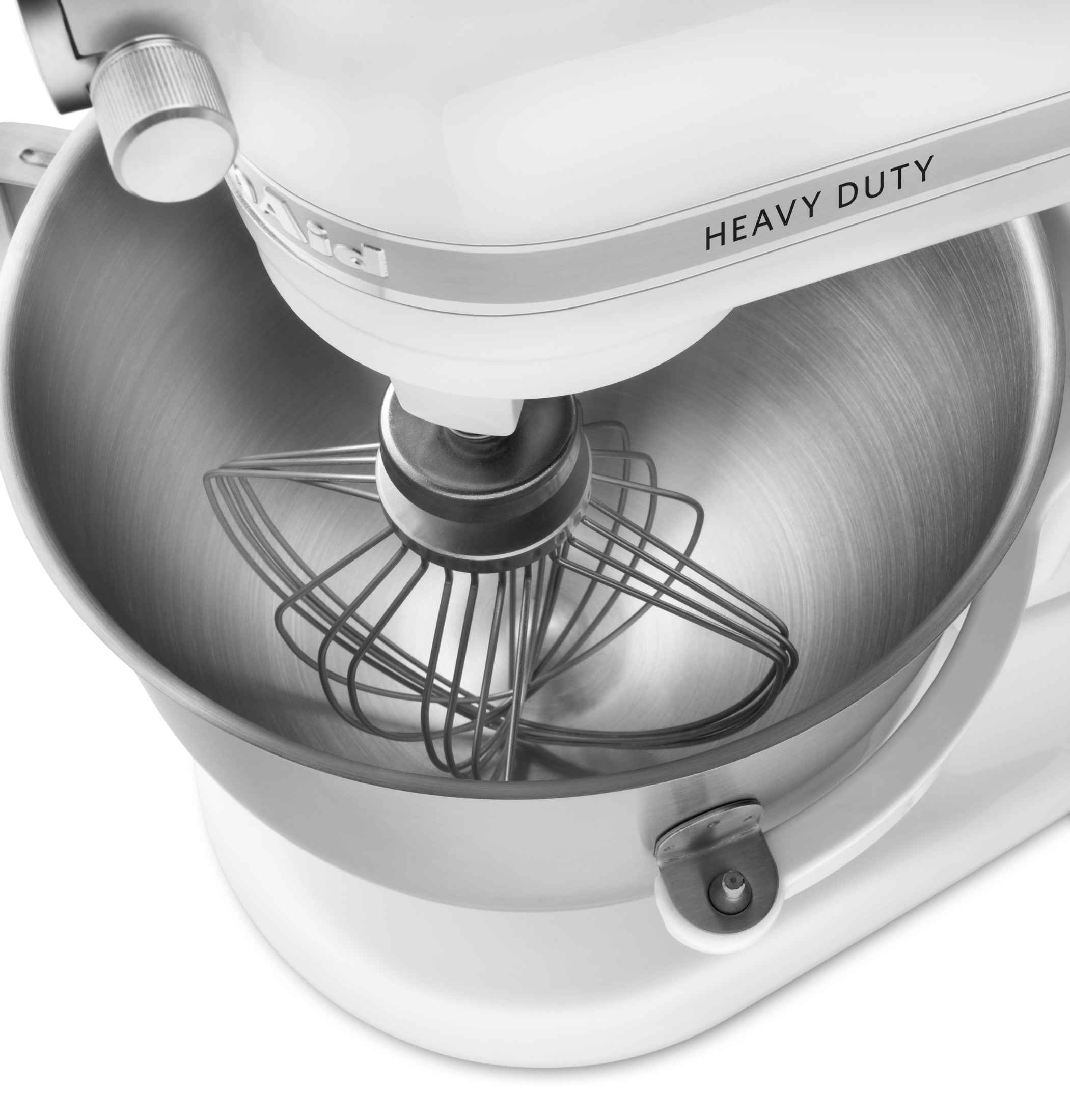 Eine weiße Küchenmaschine mit "Heavy Duty"-Aufschrift und Schneebesen im Edelstahldom.