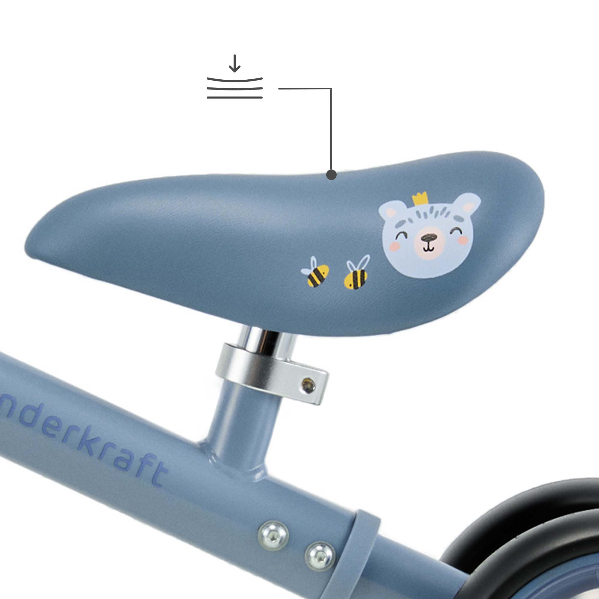 Blauer Fahrradsattel mit Bären- und Bienenmotiv. Federungssymbol.