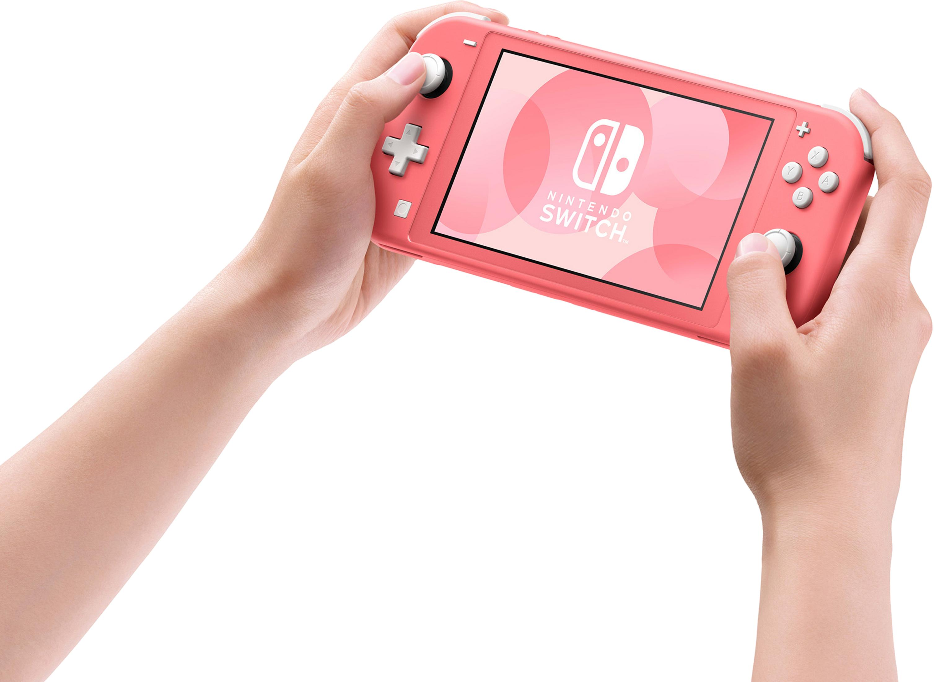 Una Nintendo Switch Lite coralina es sostenida por manos.