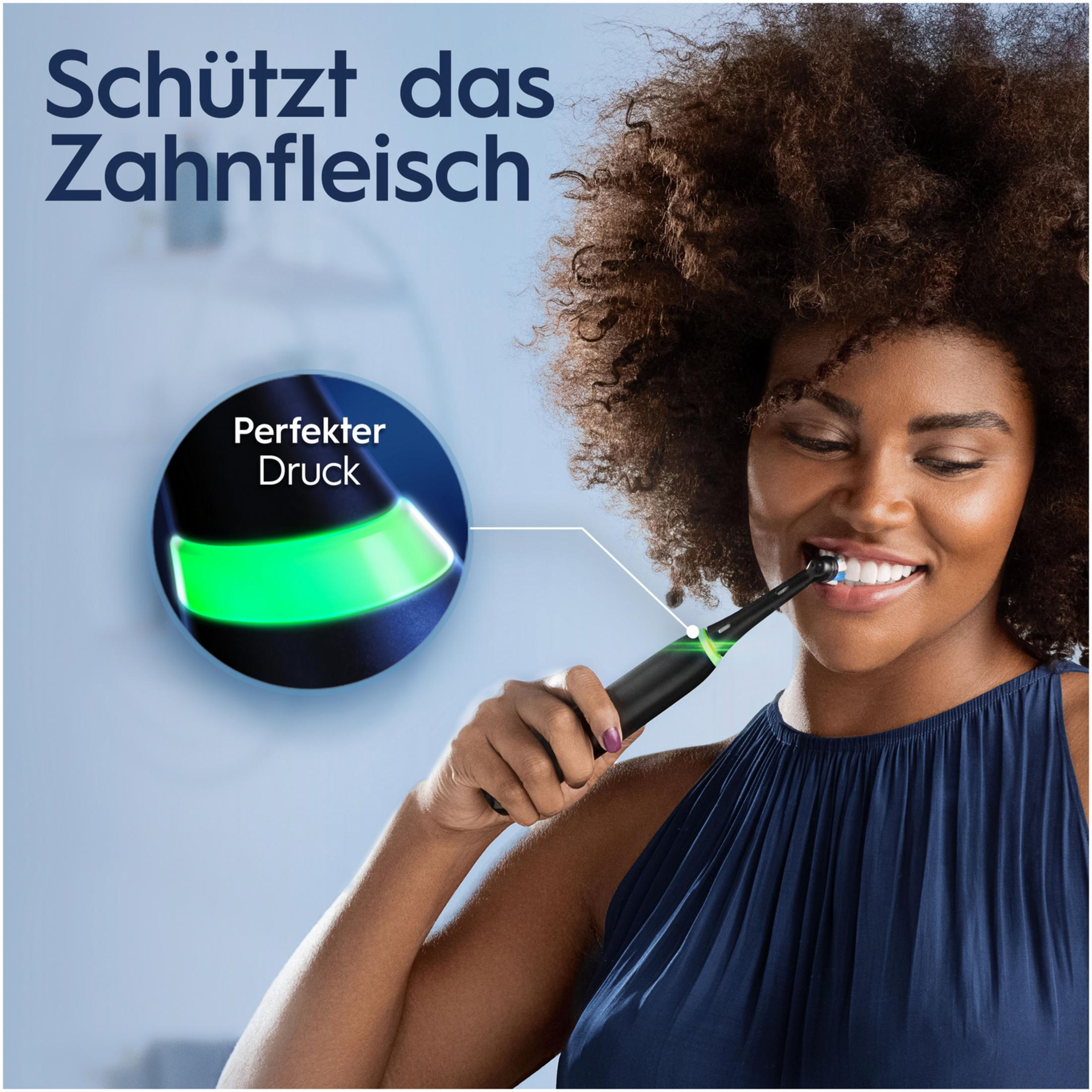 Frau putzt sich die Zähne mit elektrischer Zahnbürste, grüne Anzeige leuchtet.