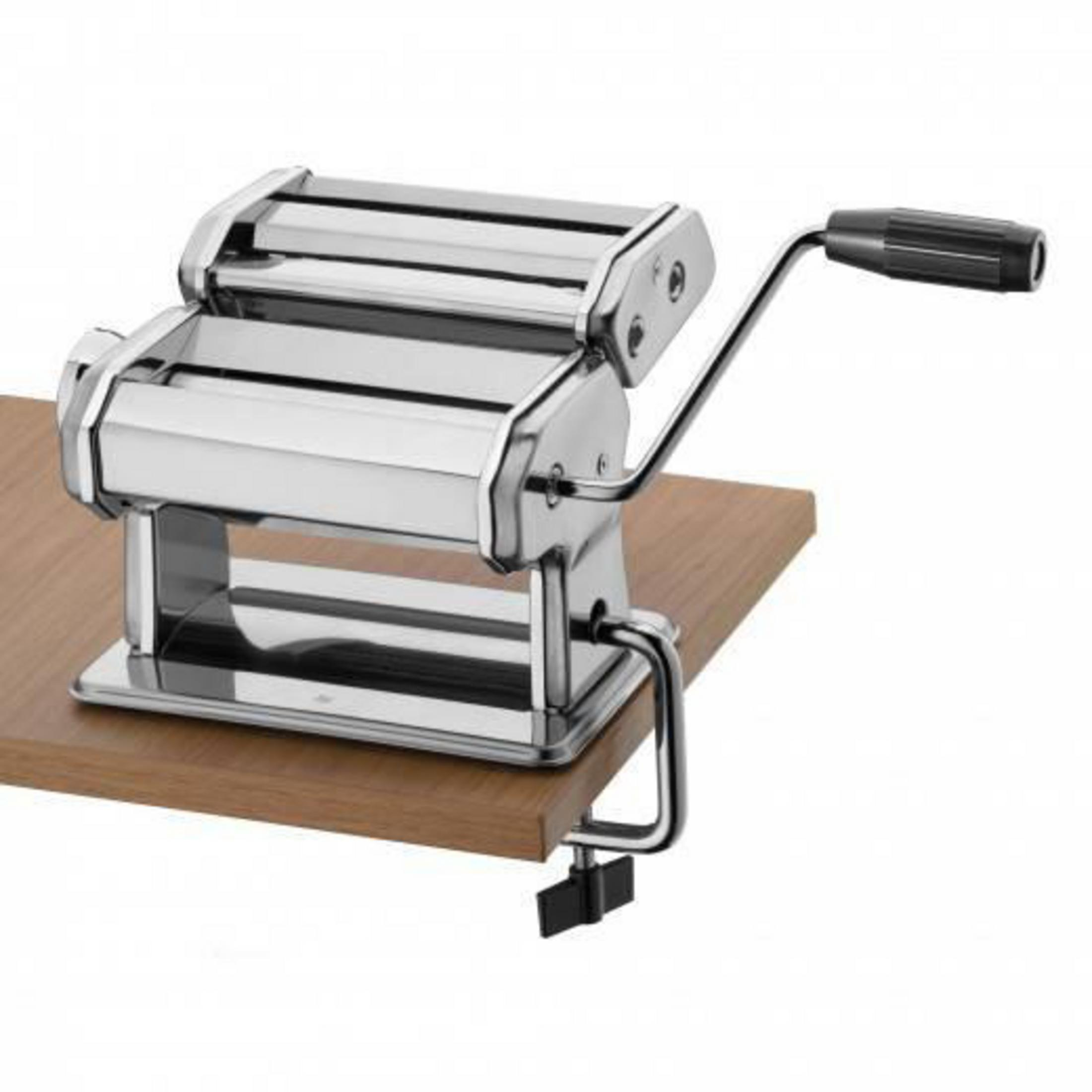 Eine glänzende Nudelmaschine aus Metall, die an einem Holztisch befestigt ist.