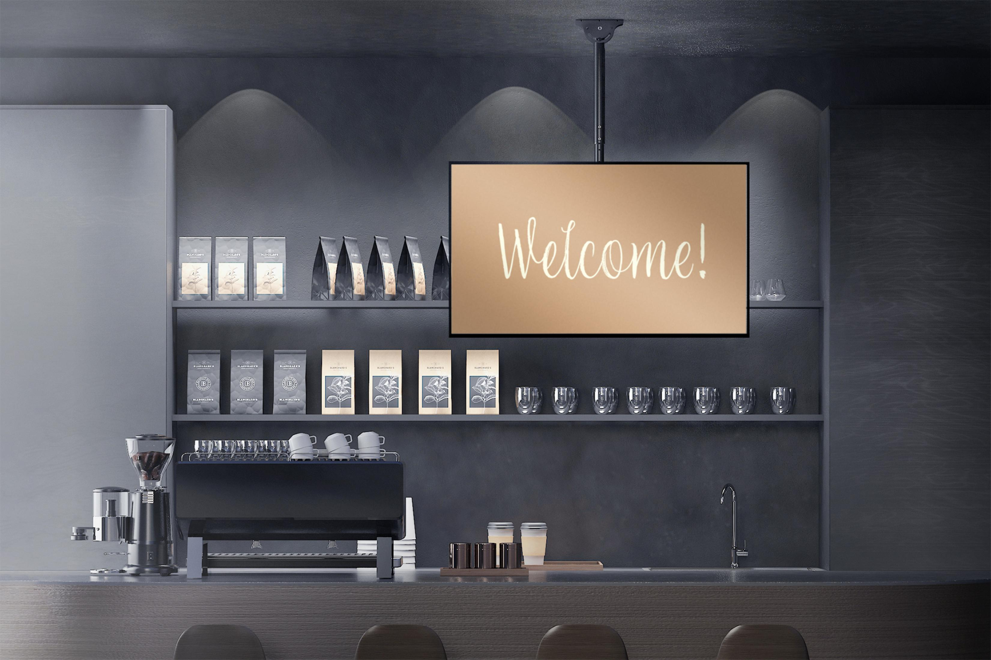 Kaffeebar mit Kaffeemaschine, Kaffeepackungen, Tassen und einem "Willkommen!"-Schild.