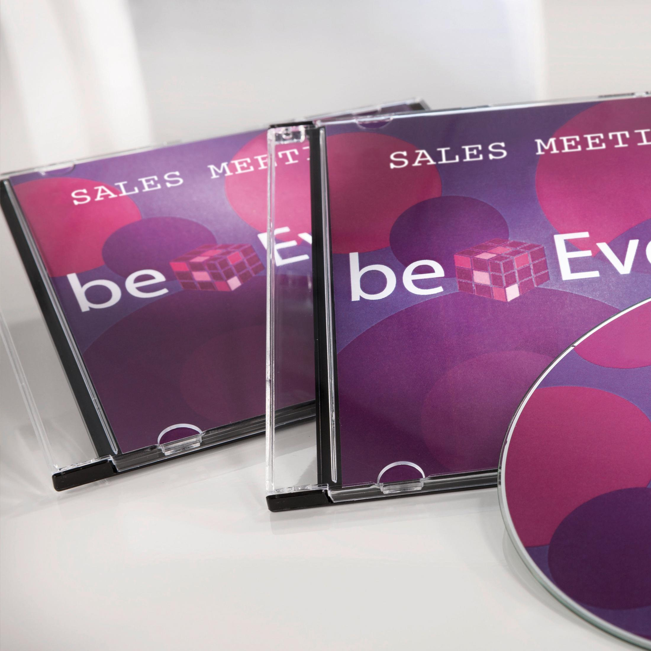 Drei CD-Hüllen mit lila Kreisen und einem Würfelmotiv. Text: SALES MEETING.