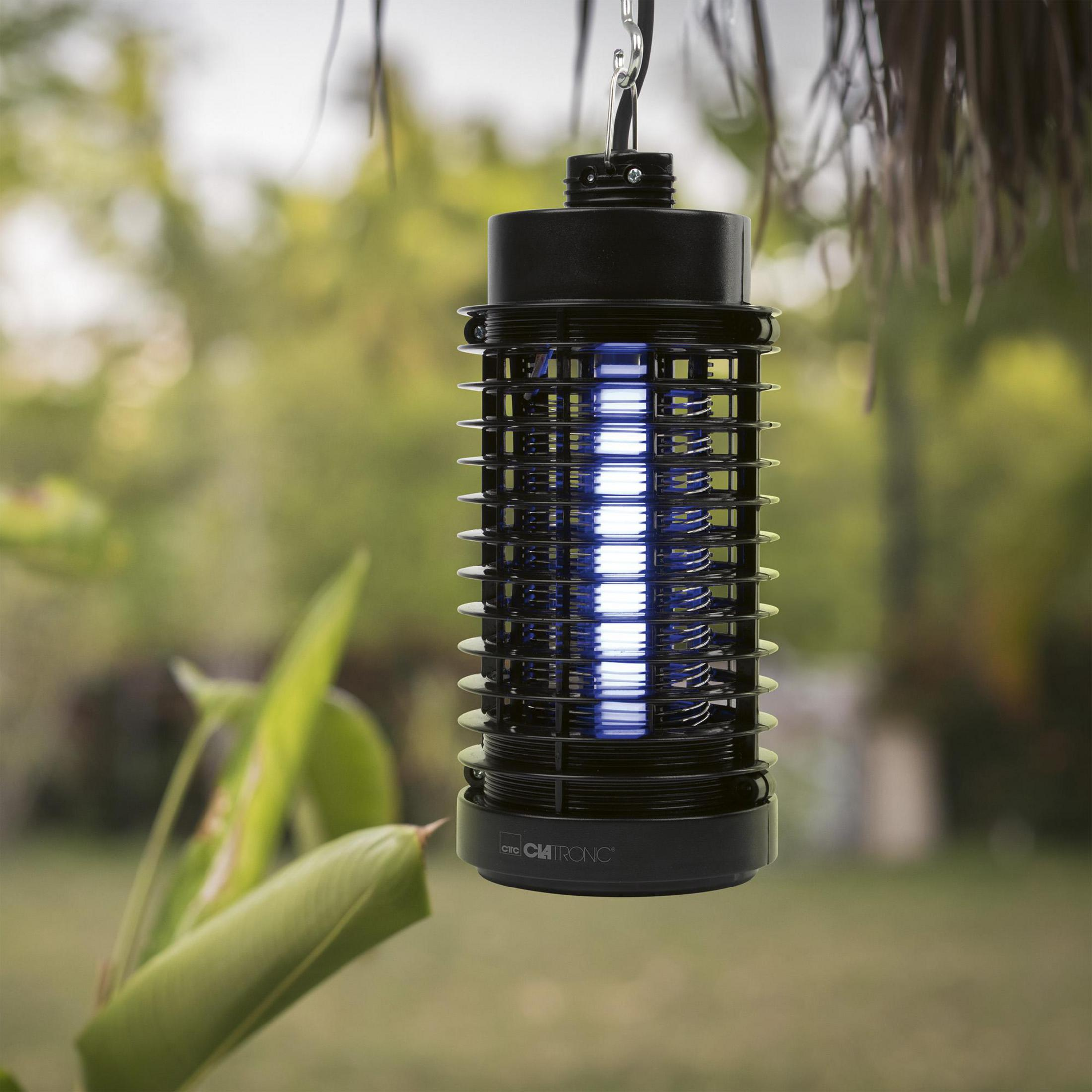 Czarny zabójca owadów z niebieskim światłem UV wisi na zewnątrz.