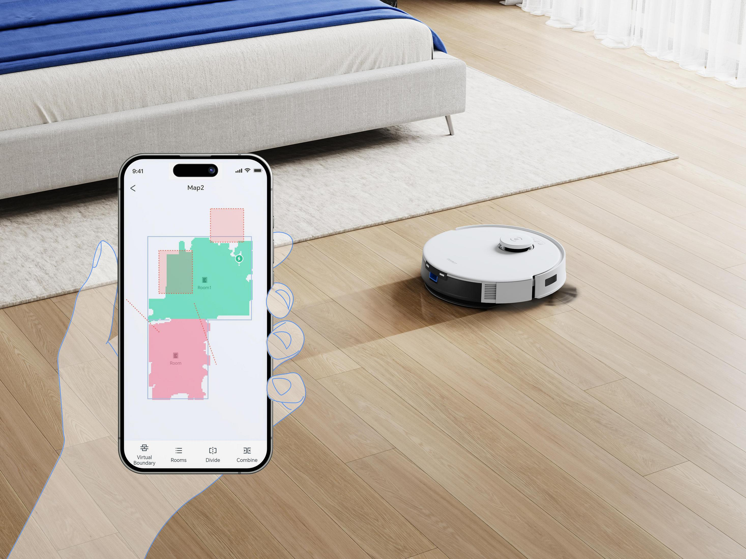 Ein weißer Saugroboter reinigt auf einem Holzboden neben einem Bett. Ein Smartphone zeigt eine Karte.