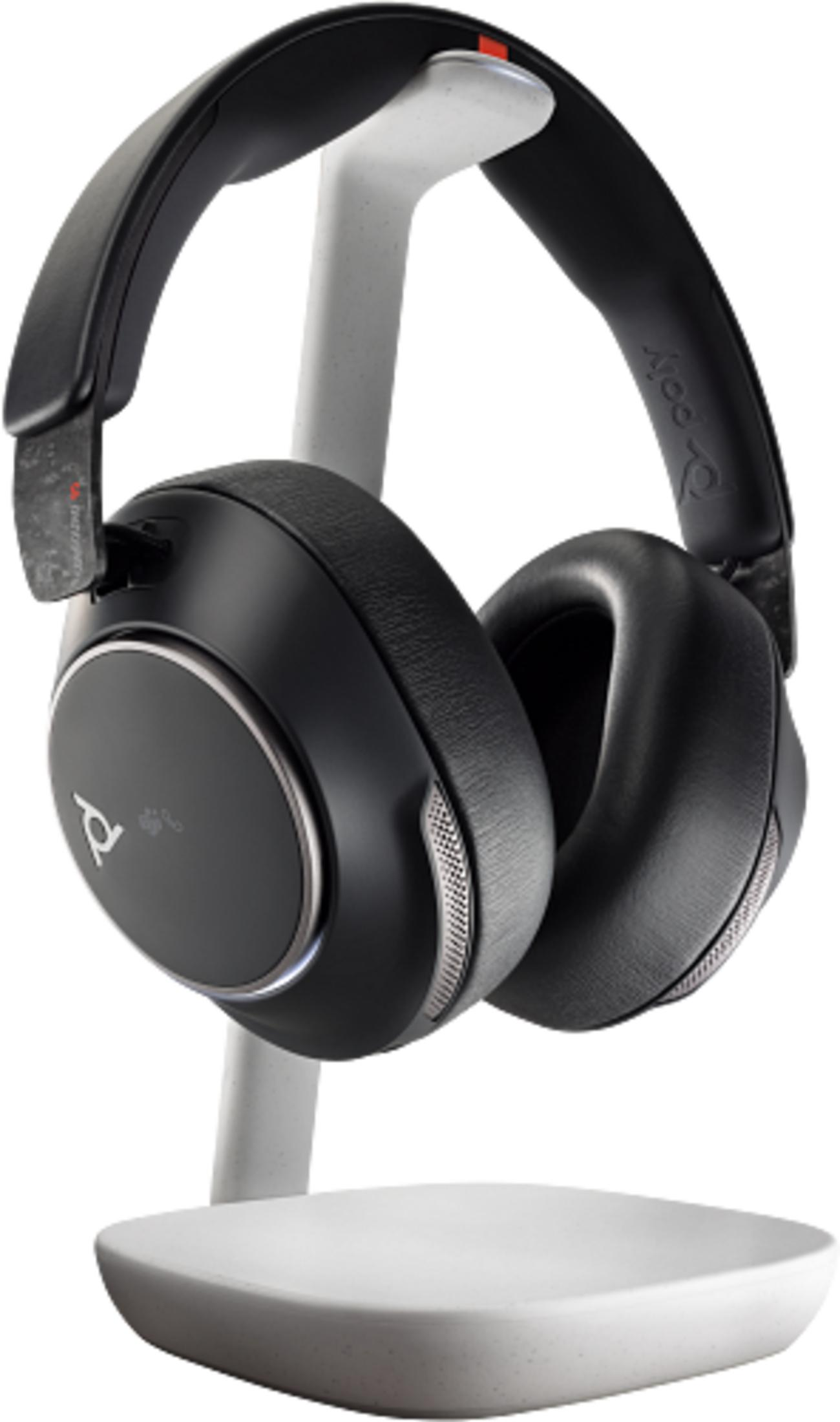 Black headphones resting on a white stand.