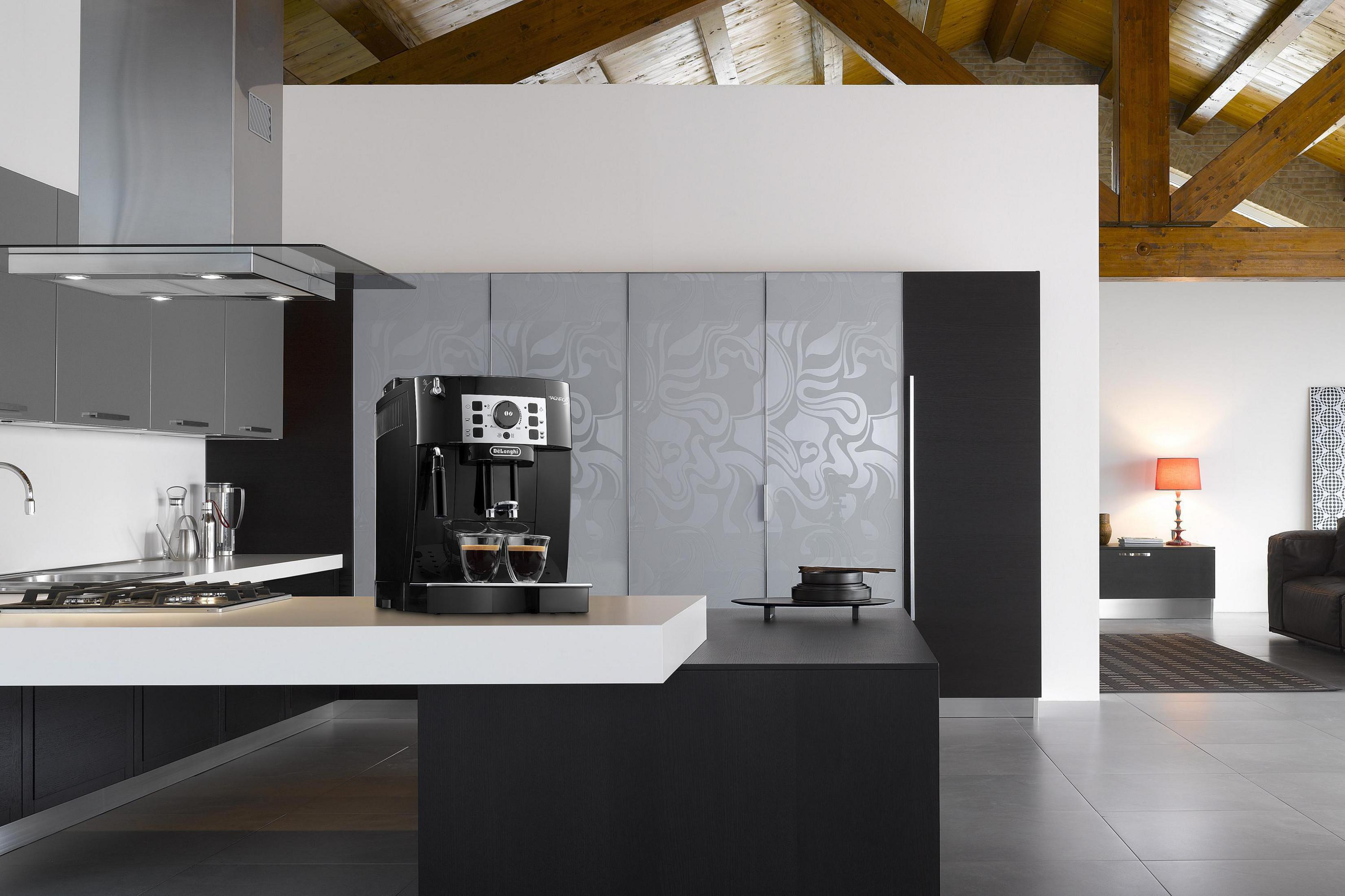 Cucina moderna con macchina da caffè e due tazzine di espresso. Travi in legno sul soffitto.