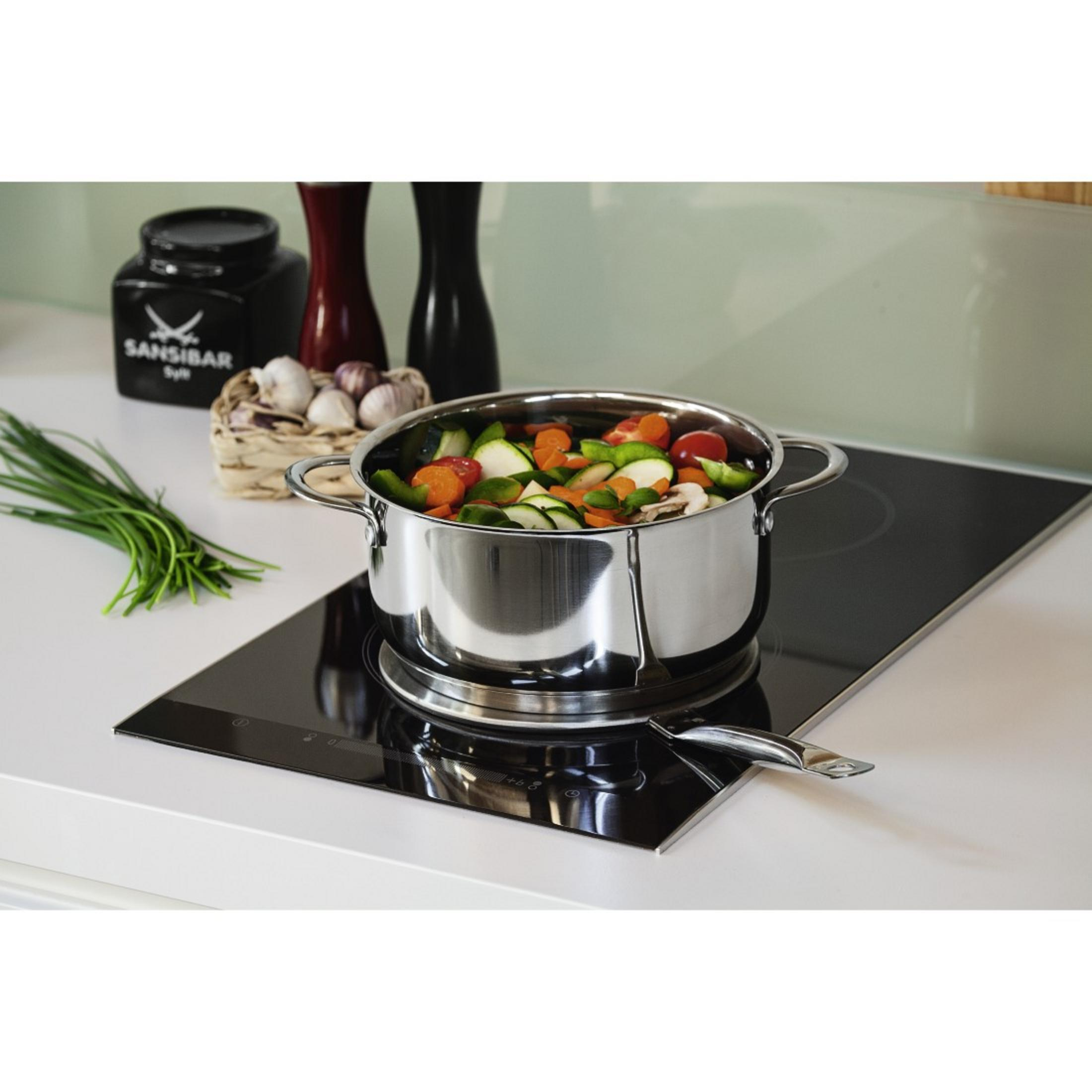 Casserole en inox avec légumes sur plaque de cuisson noire.