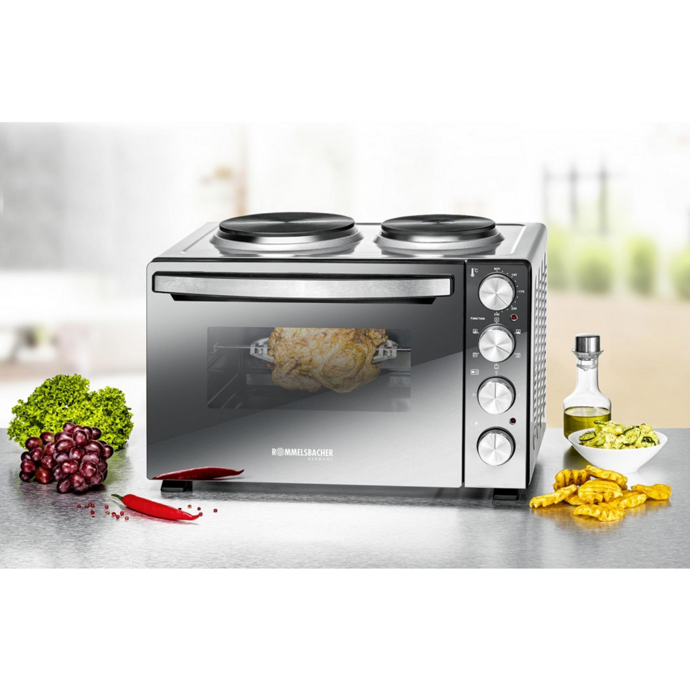 Forno in acciaio inox con pollo arrosto, uva, lattuga, peperoncino e patatine.