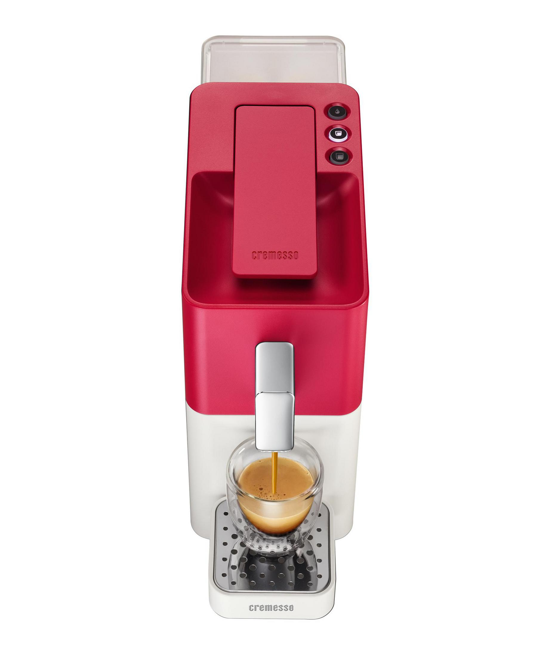 Eine rote und weiße Kaffeemaschine brüht einen Espresso in ein Glas.