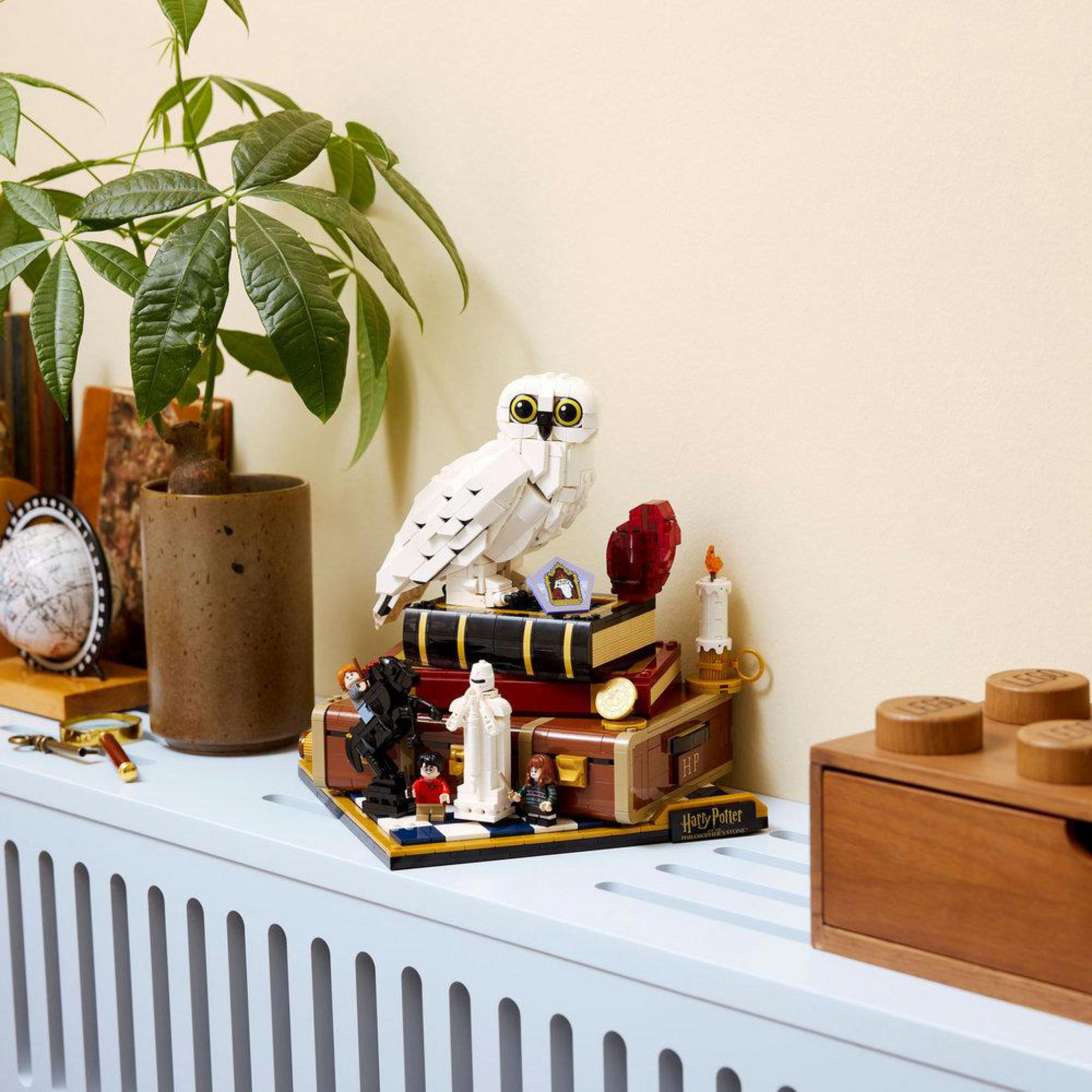 Model Lego Hedwigi na książkach z Harrym i Hermioną.