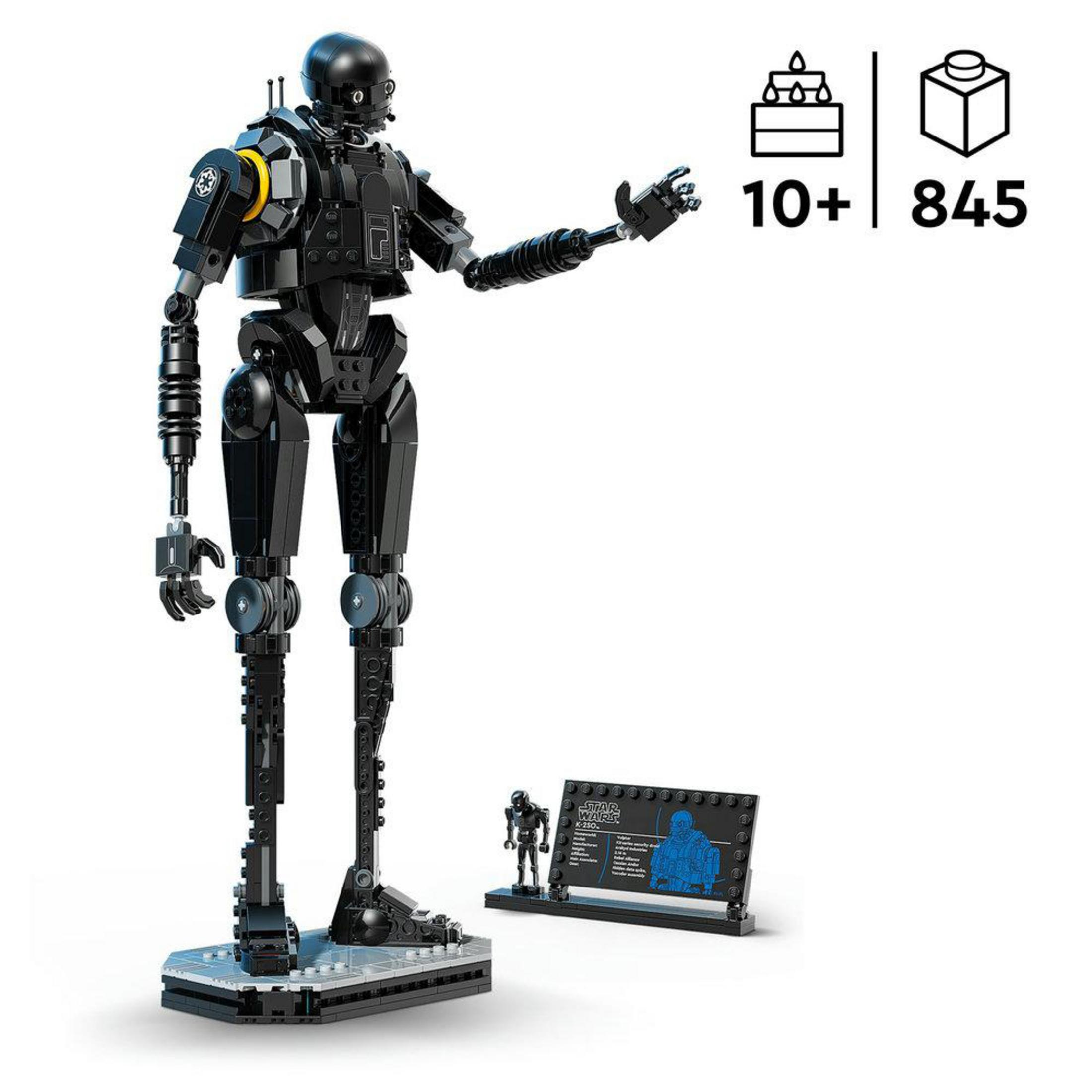 Czarny droid LEGO z żółtymi akcentami na postumencie z tablicą informacyjną.