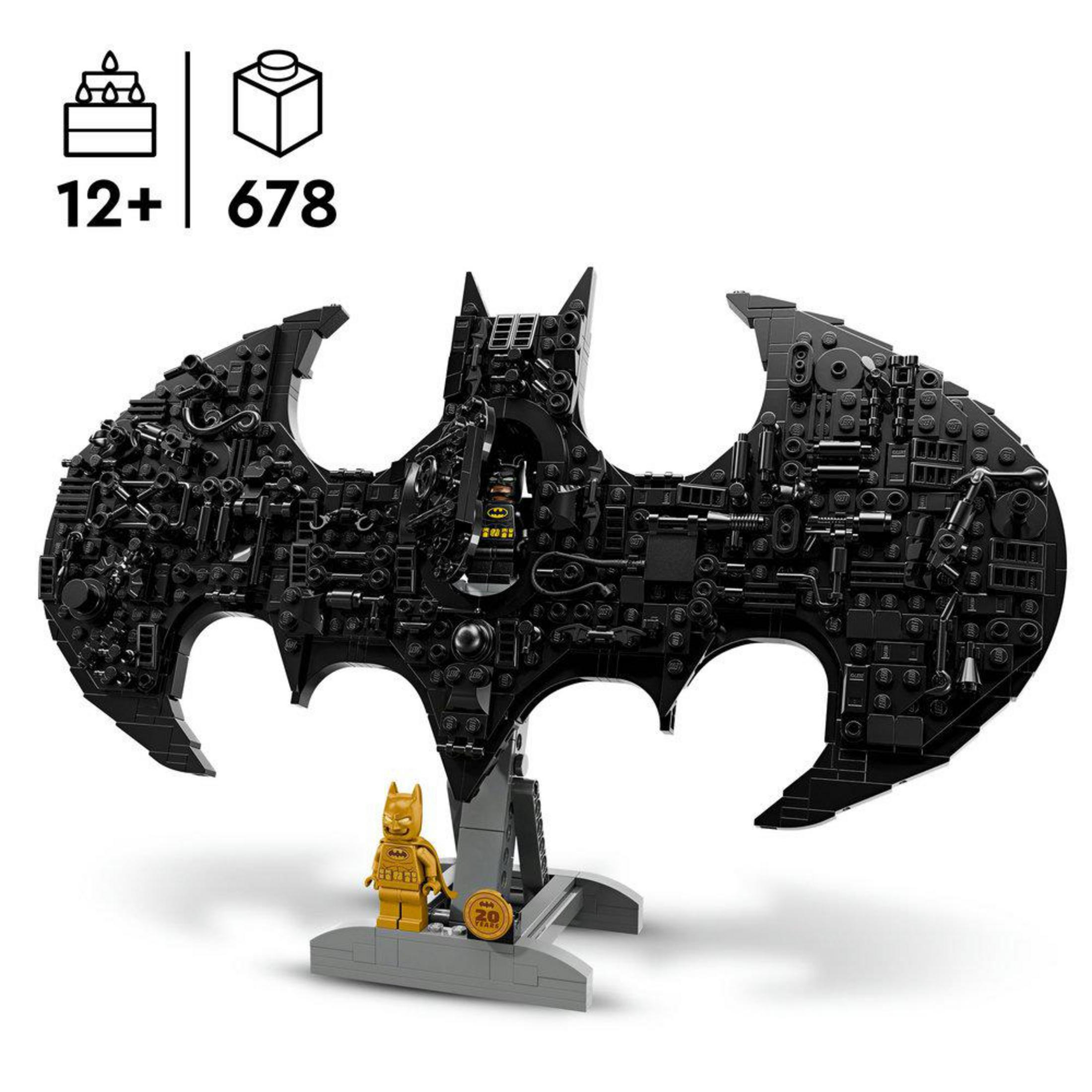 Altın bir minifigürlü, stand üzerinde siyah Lego yarasa sembolü.