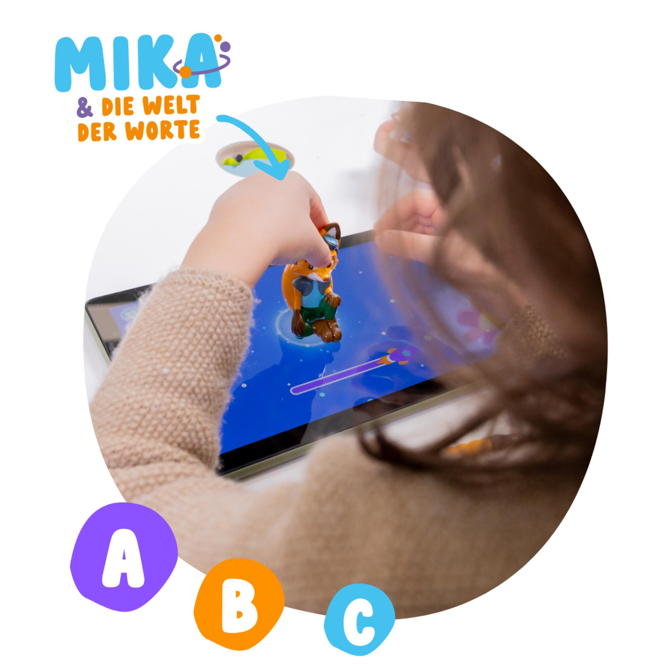 Kind spielt mit Fuchsfigur auf Tablet mit bunter Grafik und Buchstaben A, B, C.