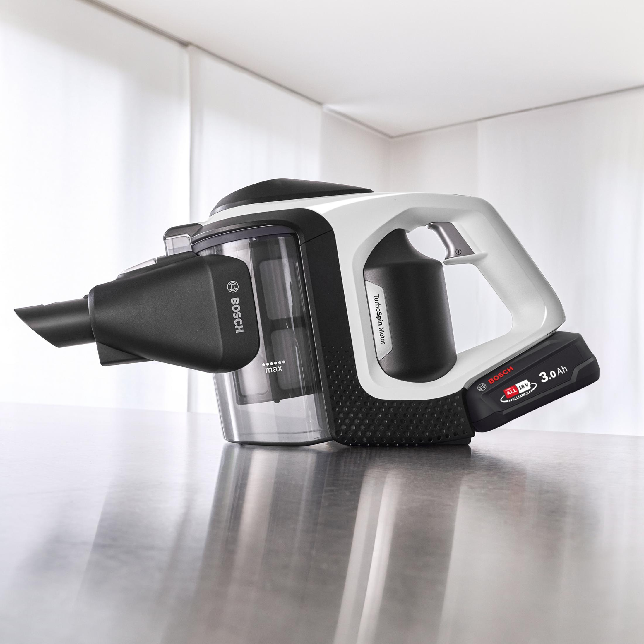Ein kabelloser Bosch-Staubsauger mit weißem und schwarzem Design auf einem Tisch.