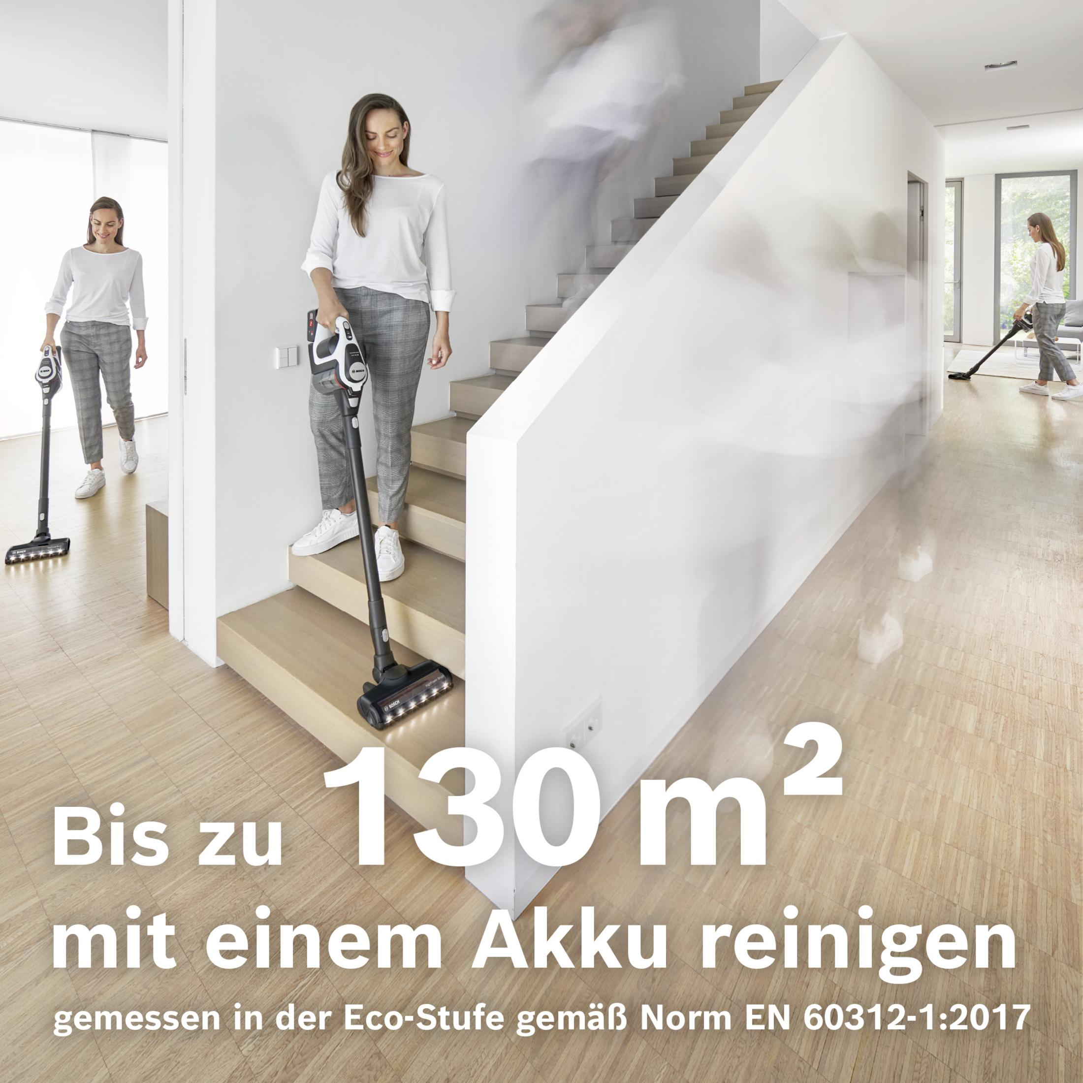 Frau saugt Treppe und Flur. Bis zu 130 m² reinigen mit einem Akku.