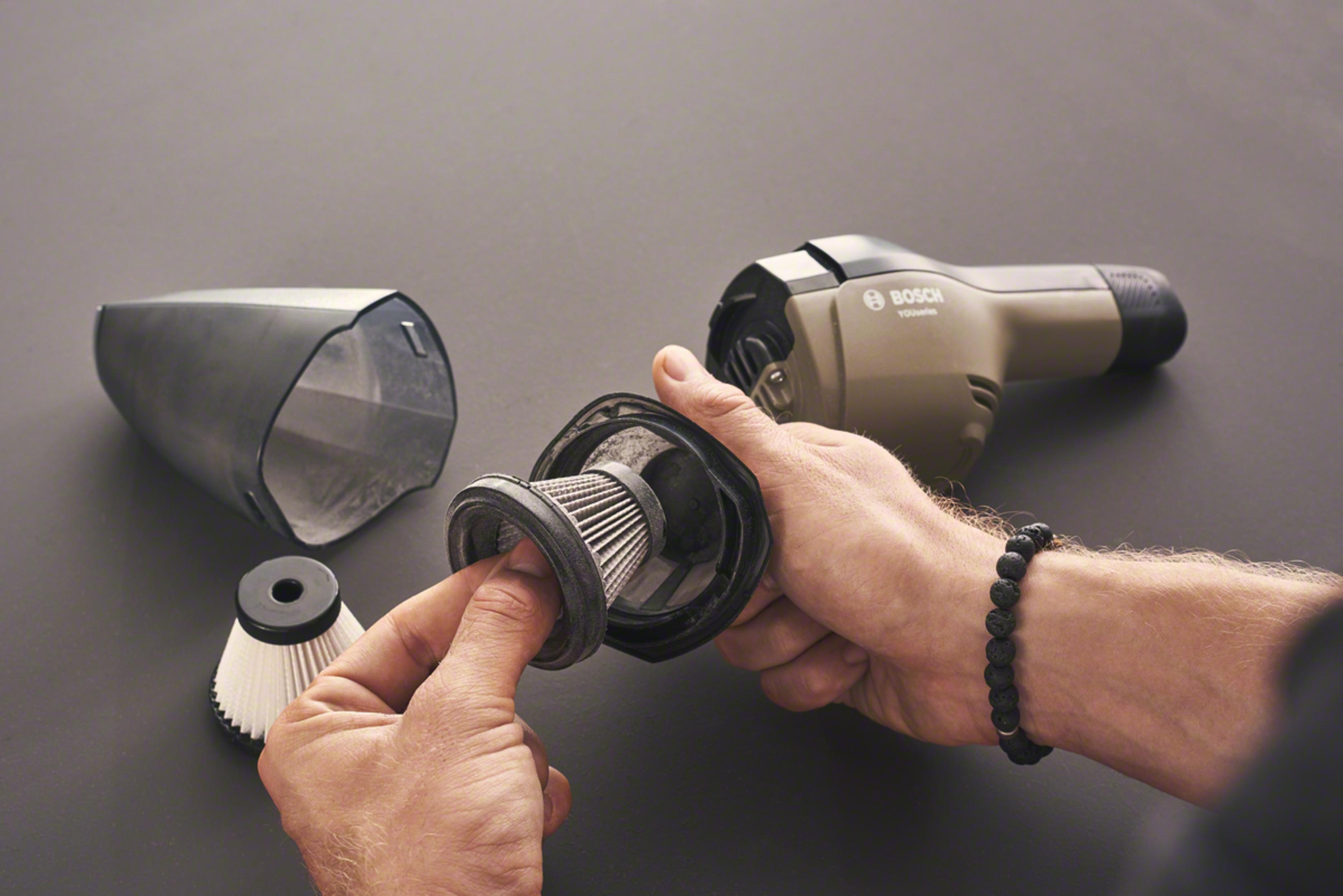 Eine Hand hält einen Staubfilter eines Bosch Akkusaugers.