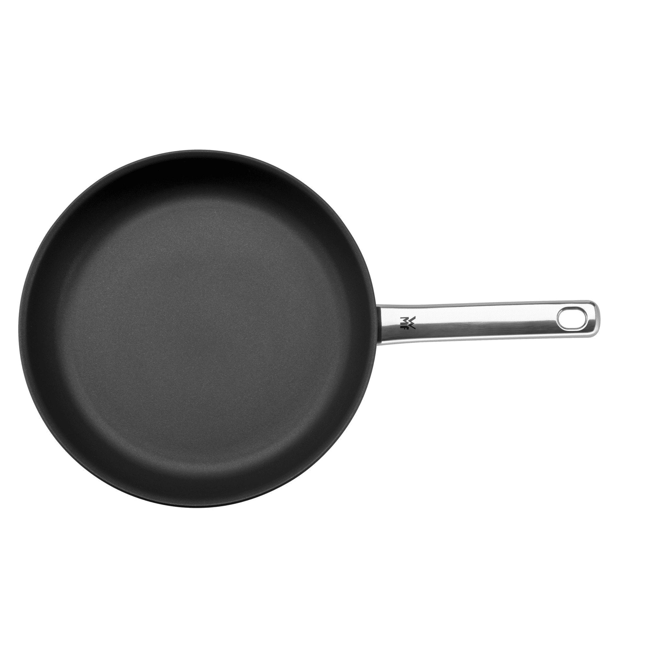 Une poêle noire avec un manche argenté sur fond blanc.