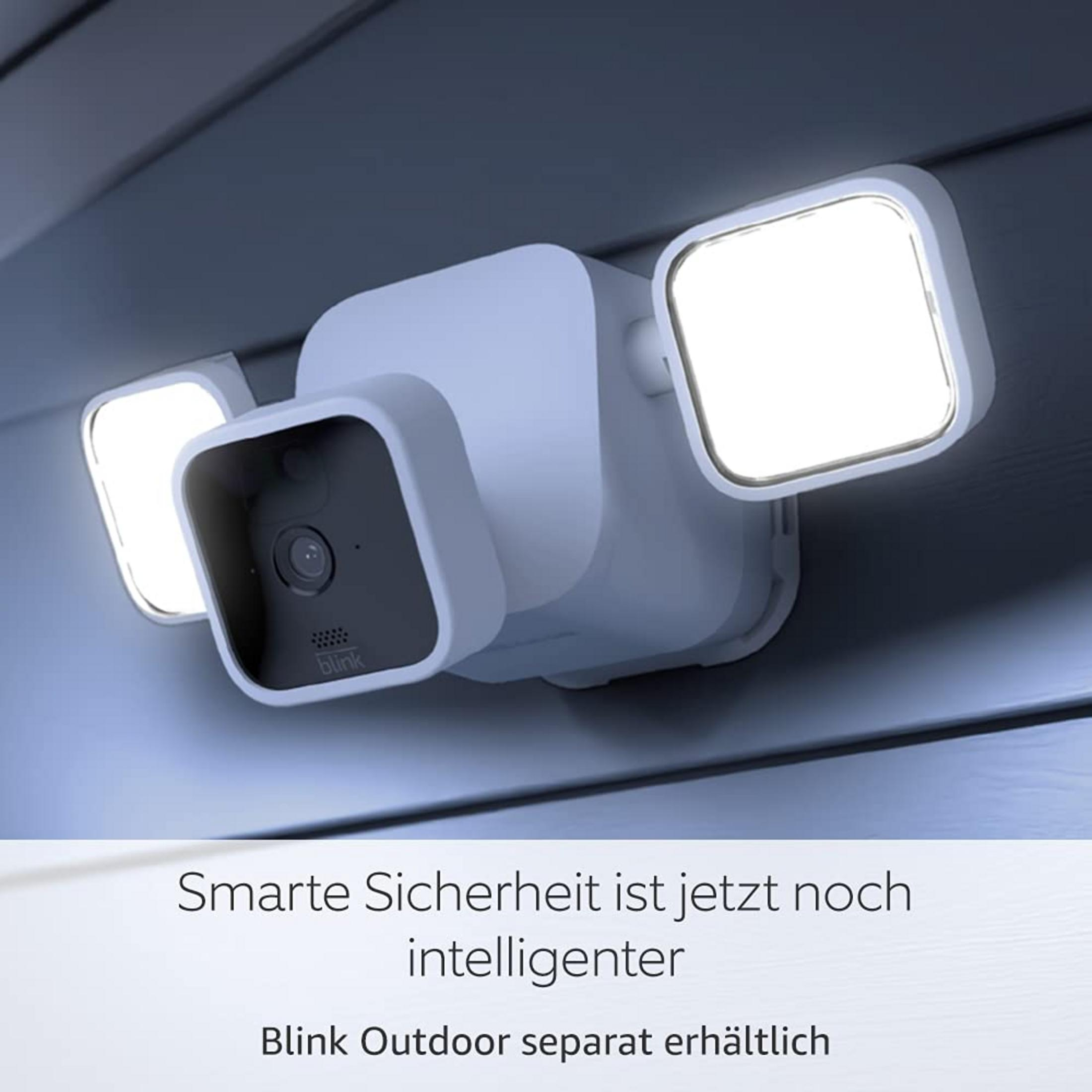 Ein weißer Blink-Außenkamera mit zwei Lichtern, montiert an einer Wand.