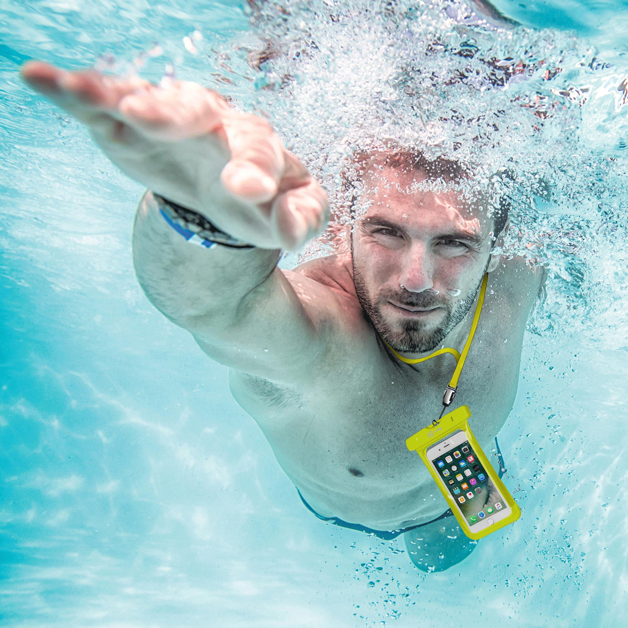 Ein Mann schwimmt unter Wasser mit einem gelben Handy-Schutzbeutel.