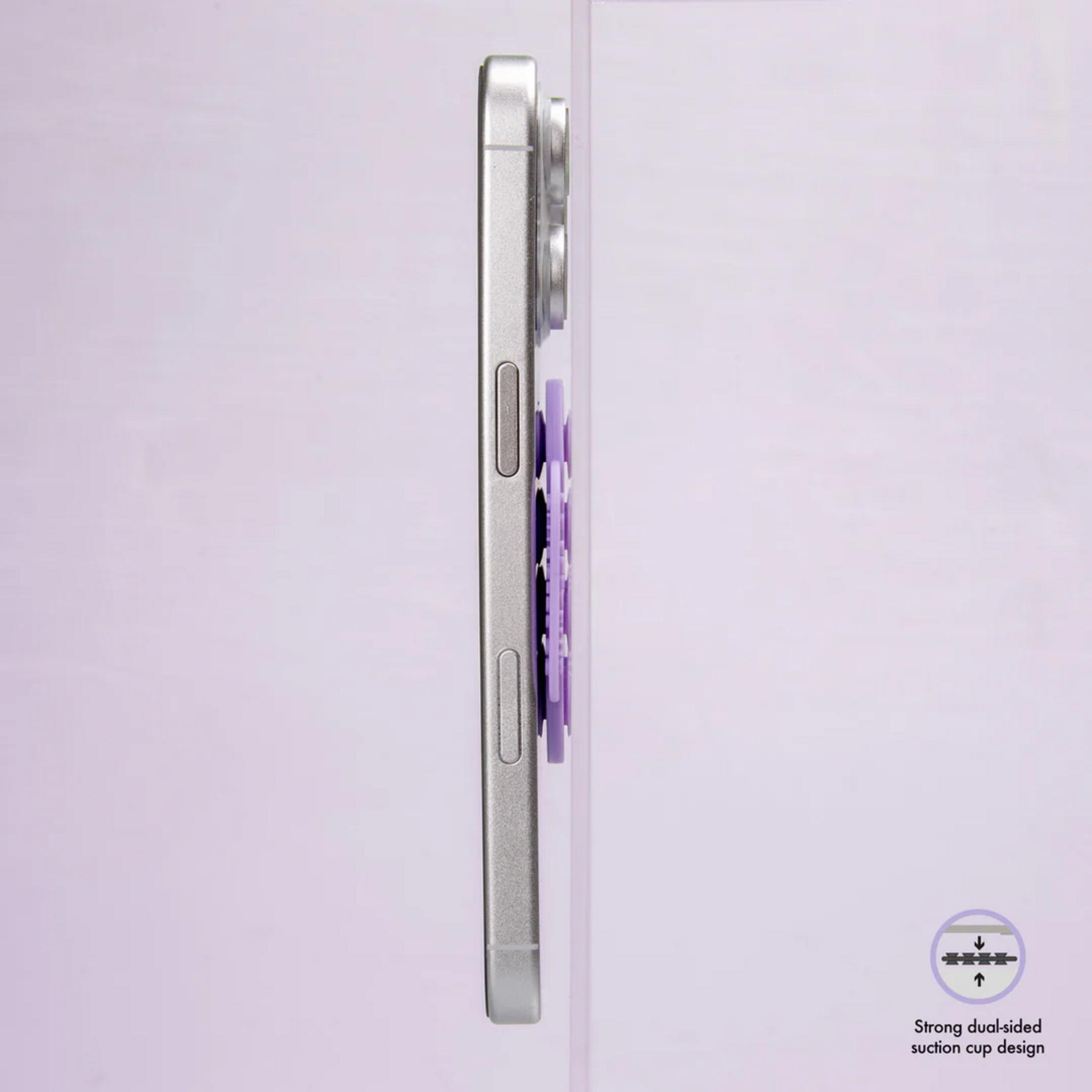 Smartphone plateado con agarre morado sobre superficie clara, vista lateral.