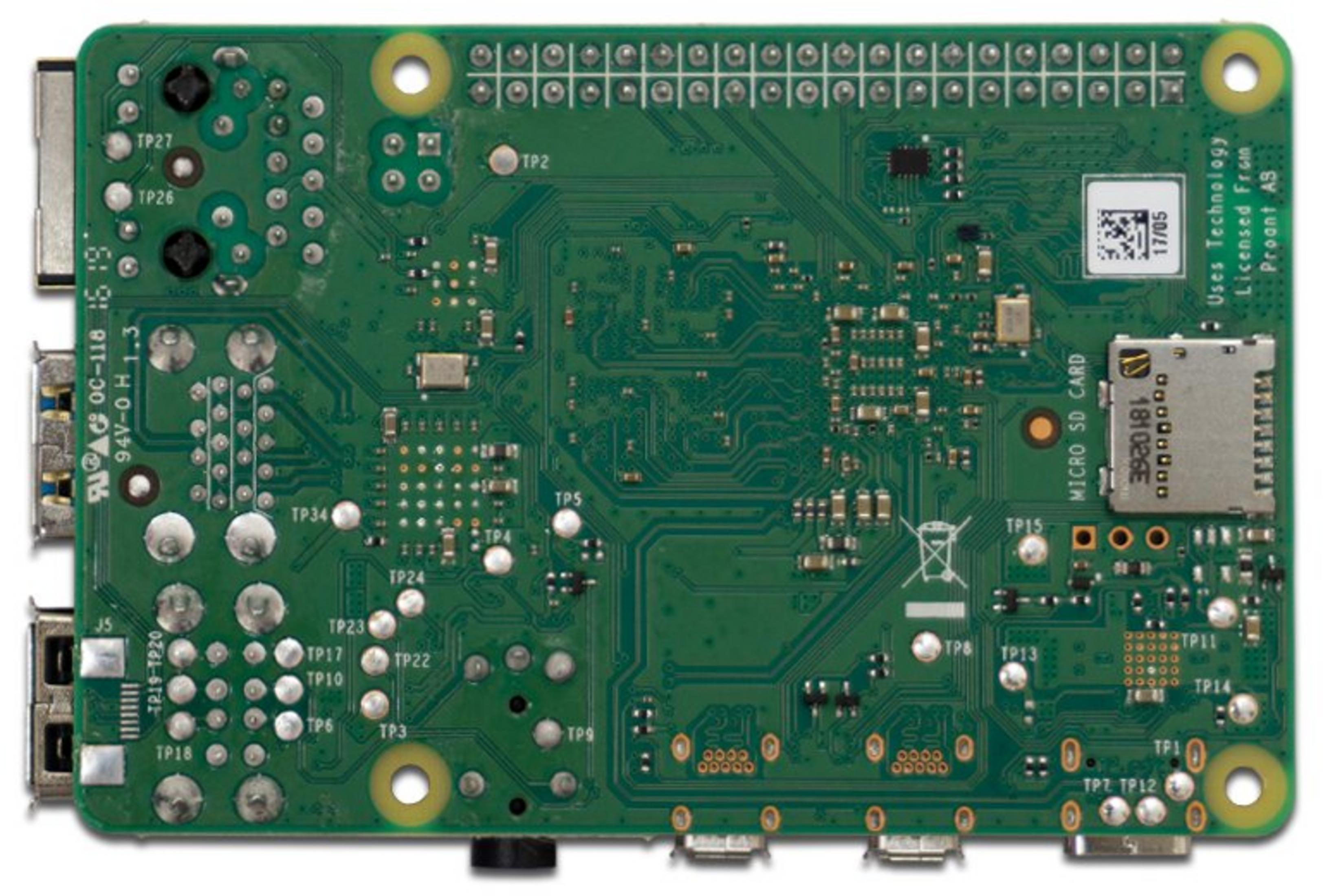 Scheda a circuito stampato verde con molti componenti elettronici, connettori ed etichette.