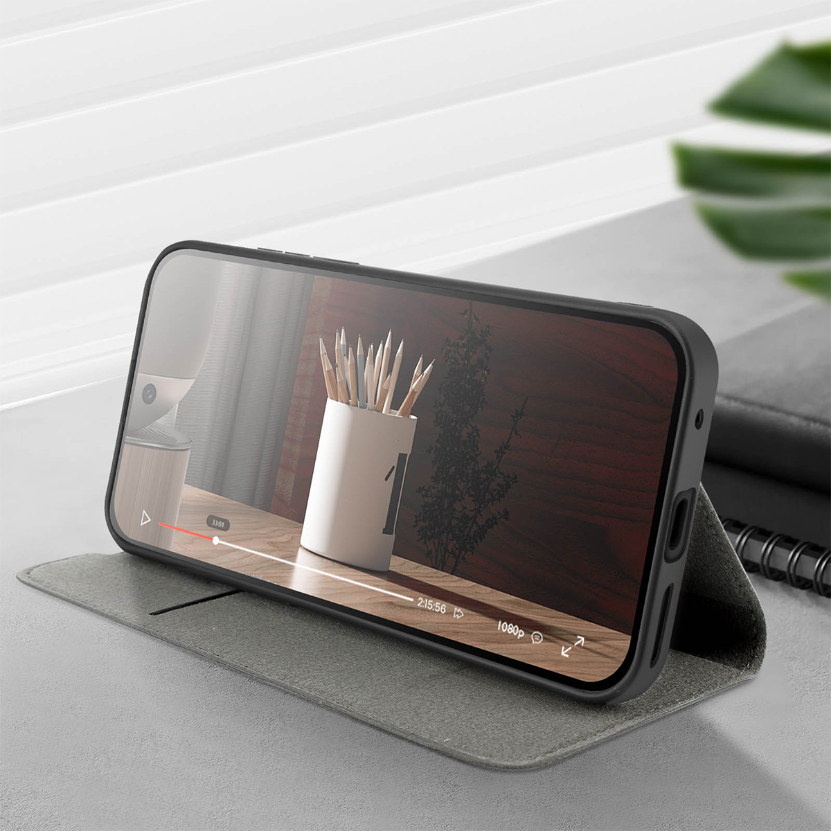 Uno smartphone in un supporto grigio mostra un video di matite in un vaso.