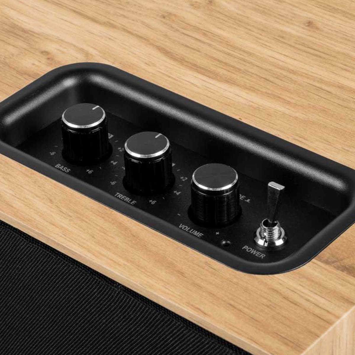 Drewniana obudowa z czarnymi pokrętłami tonów niskich, wysokich i głośności.