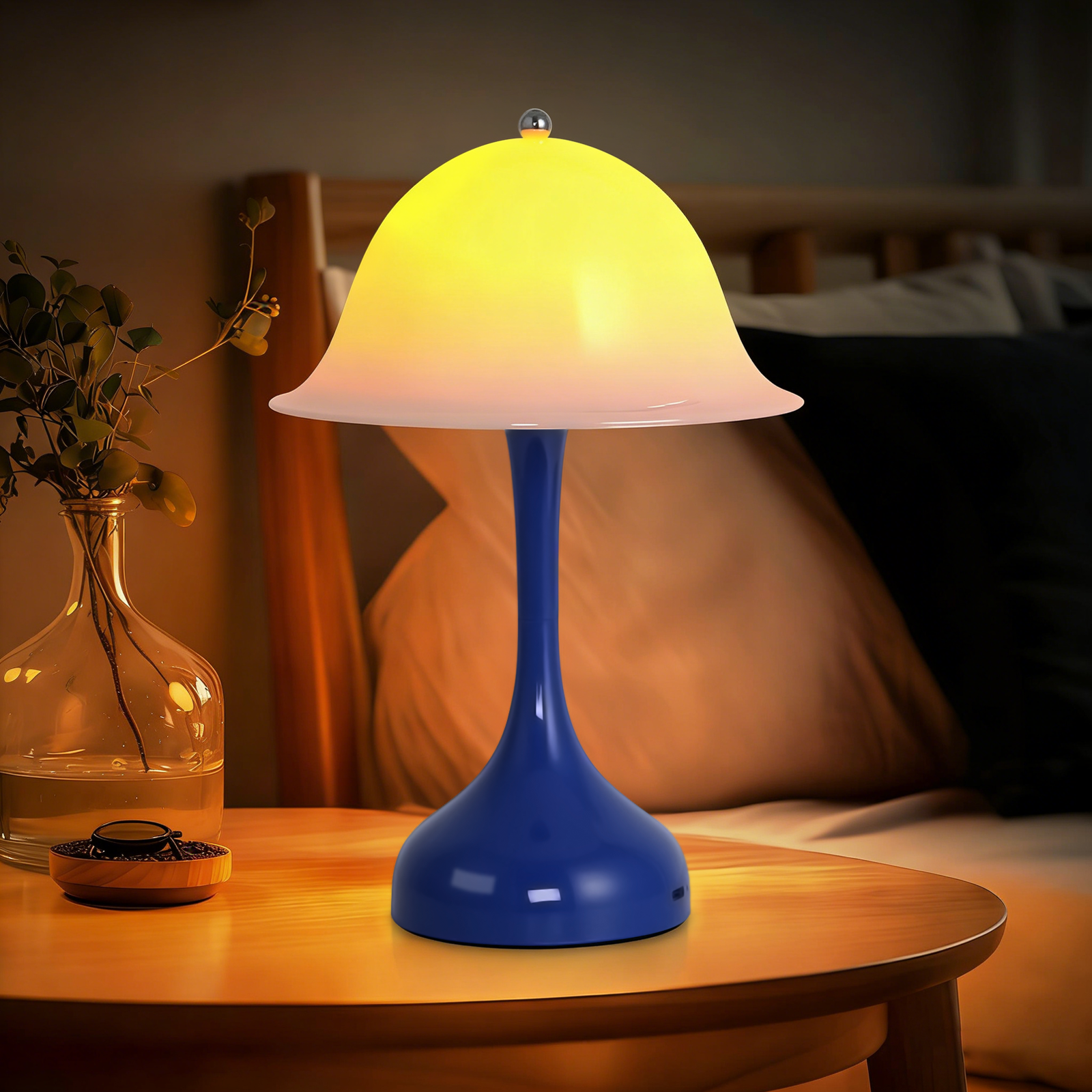 Una lampada blu con luce gialla su un comodino accanto a un letto.