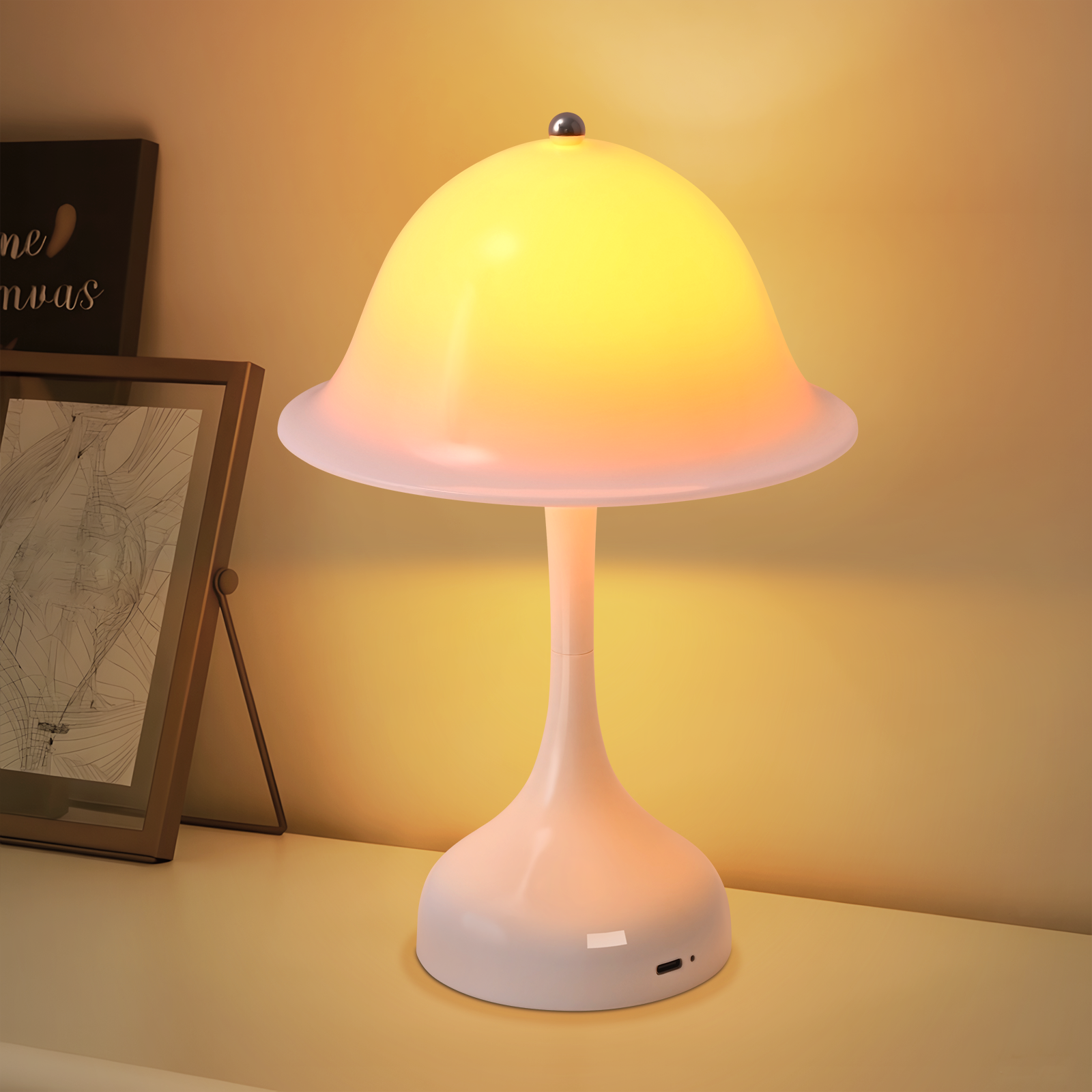 Una lampada bianca a forma di fungo brilla calorosamente su un tavolo, con una cornice vicina.