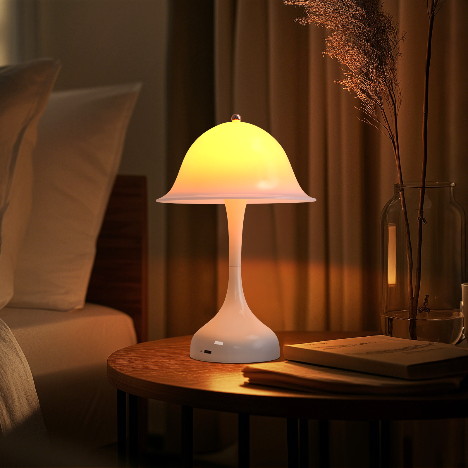 Una lampada bianca a forma di fungo su un tavolino rotondo di legno accanto a un letto.